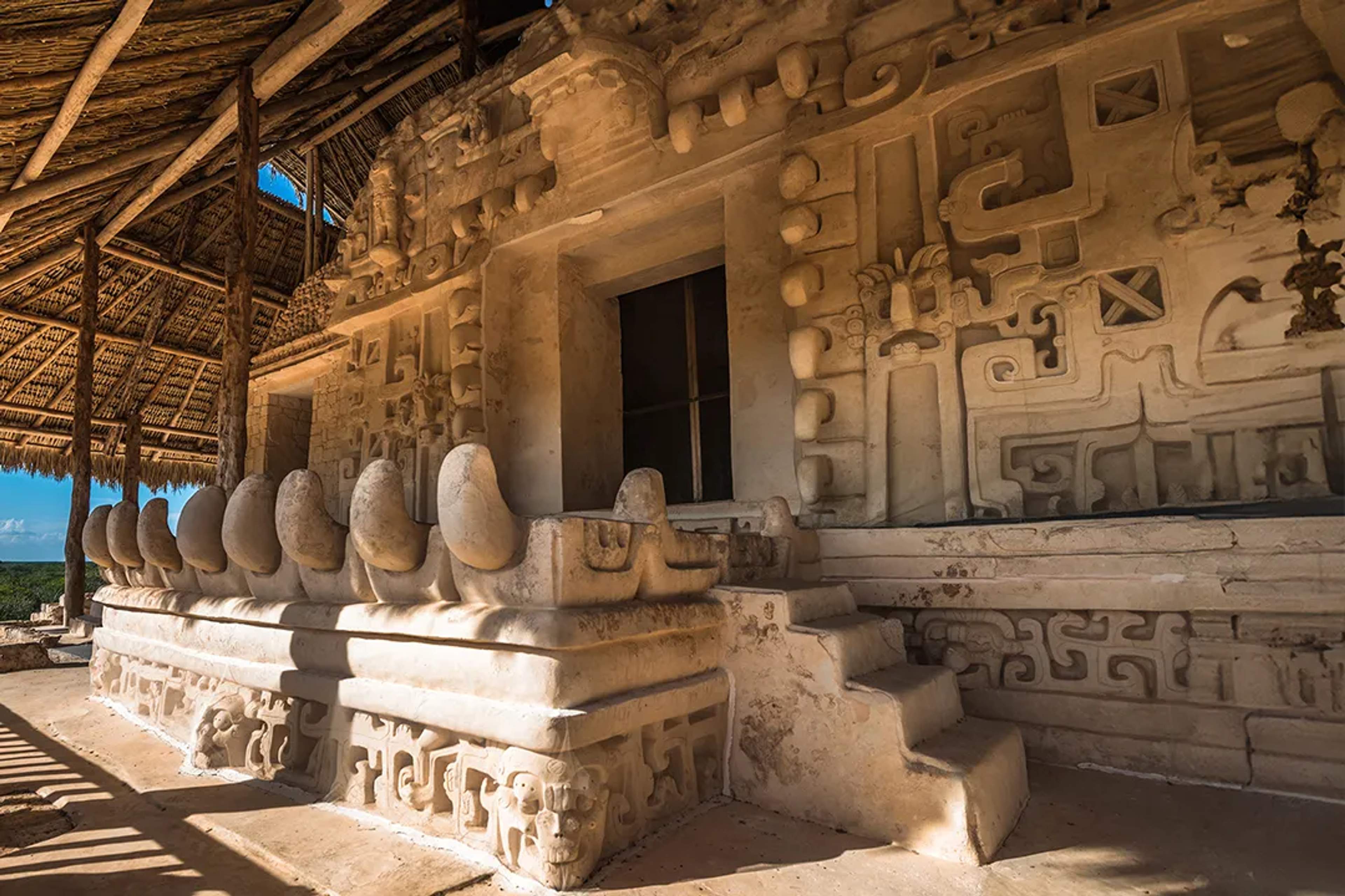 Ancient Mayan stone carvings inside a ceremonial temple, showcasing detailed reliefs and architecture in Mexico