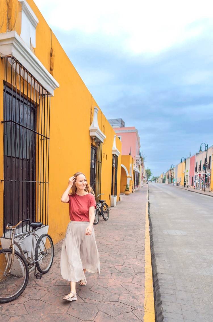 Mujer caminando en una colorida calle de Valladolid, Yucatán.