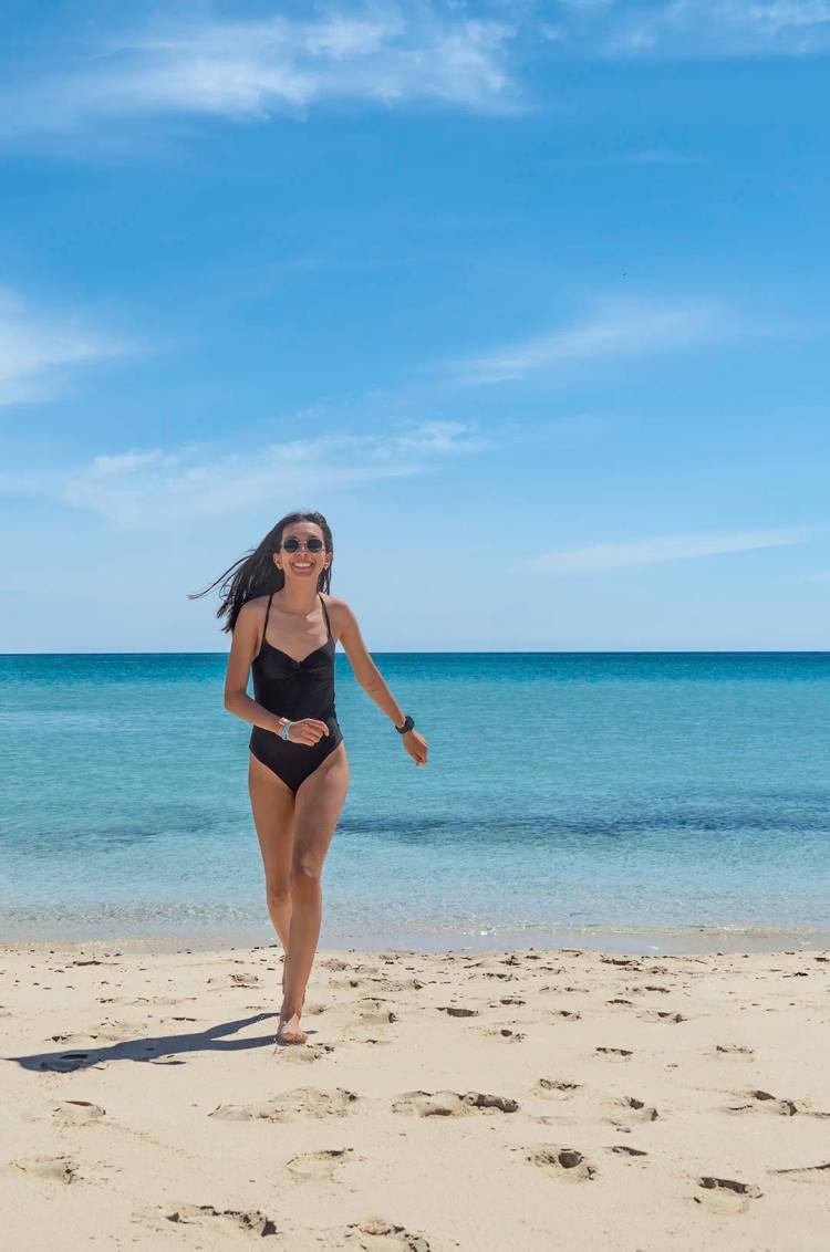 Mujer disfrutando las aguas cristalinas de una playa en Isla Mujeres.