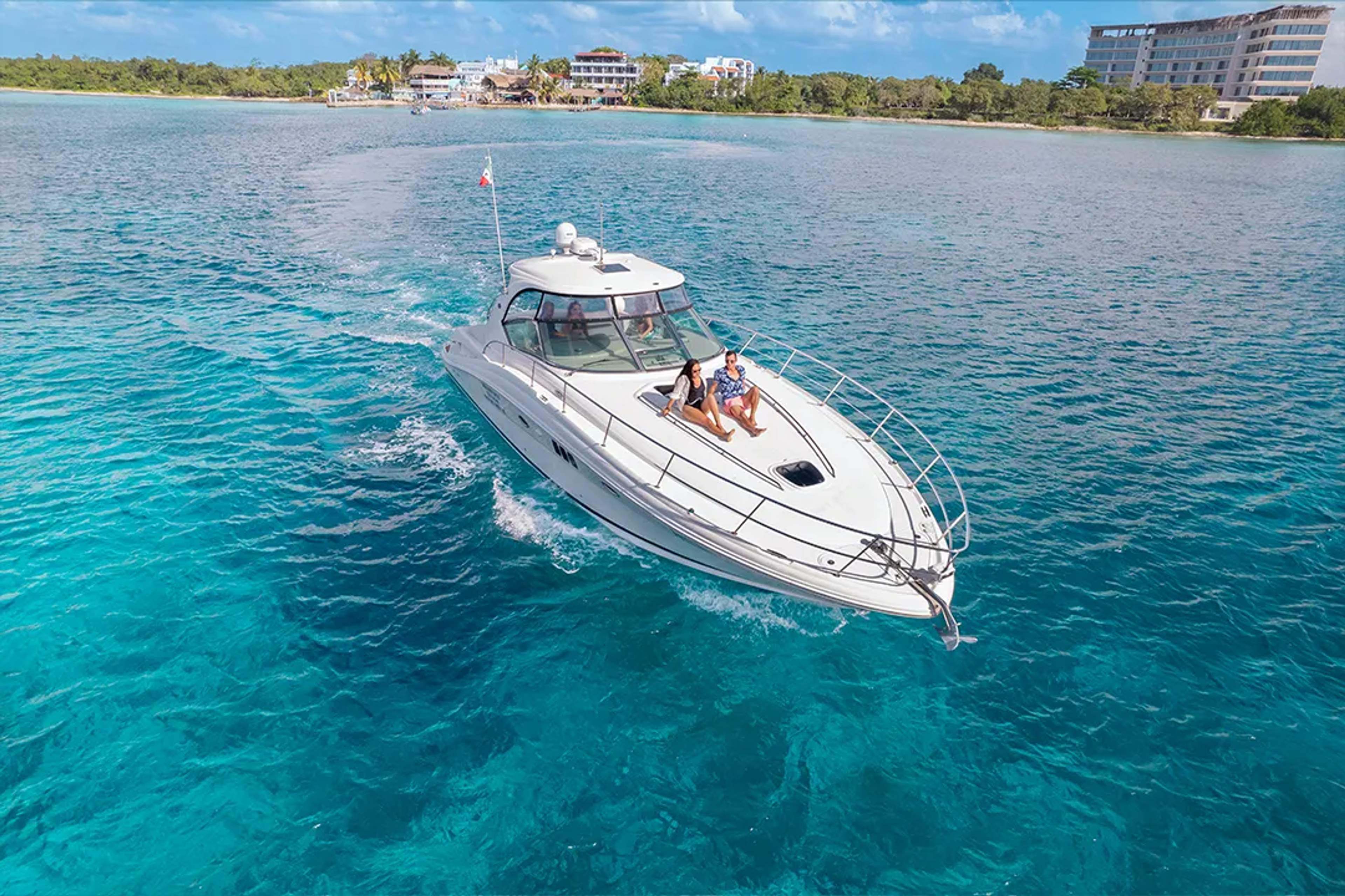 Couple relaxing on a luxury yacht sailing crystal-clear waters near the coast.