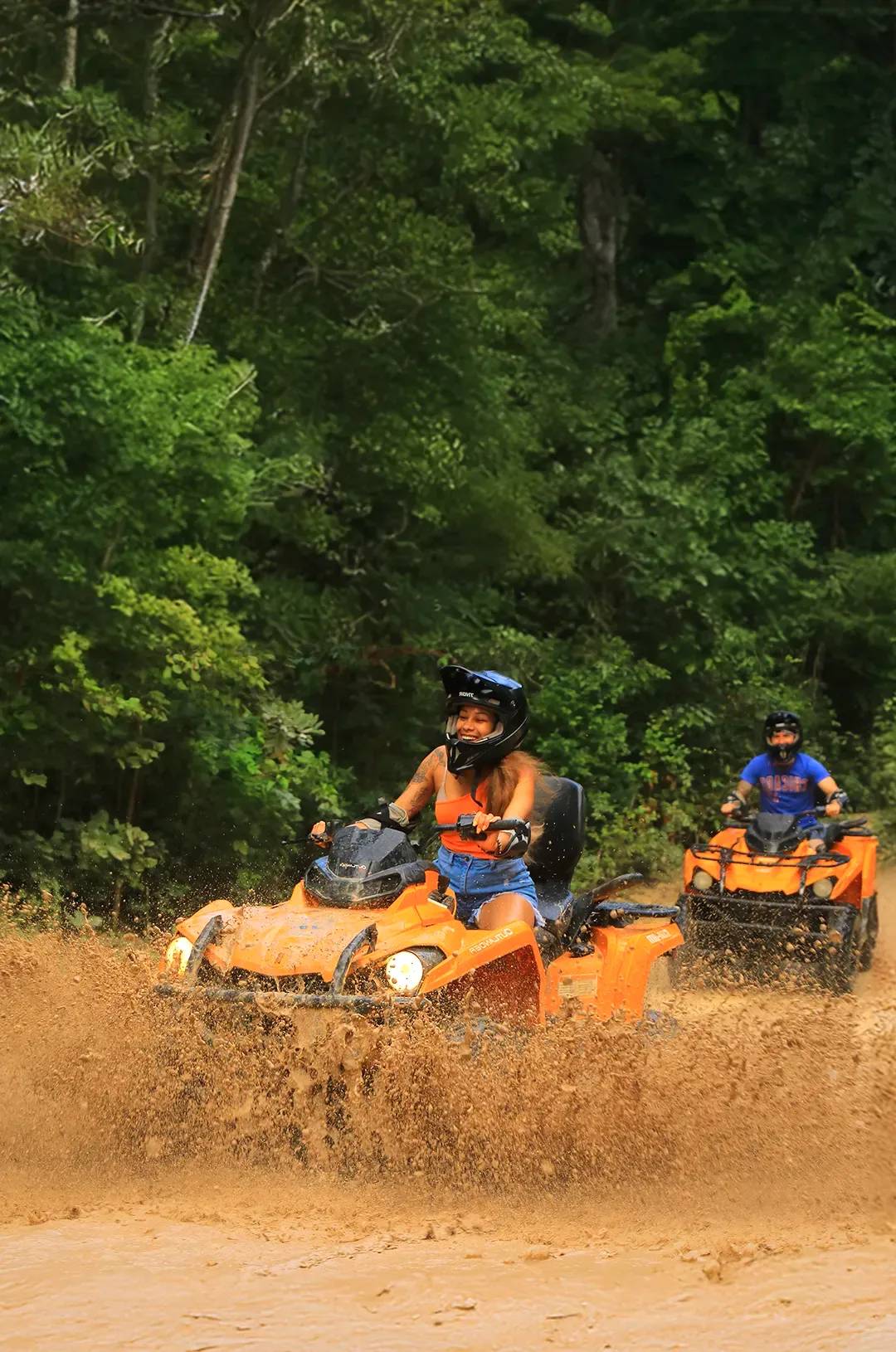 Amigos manejando cuatrimotos en Cancún a través de la selva Maya.
