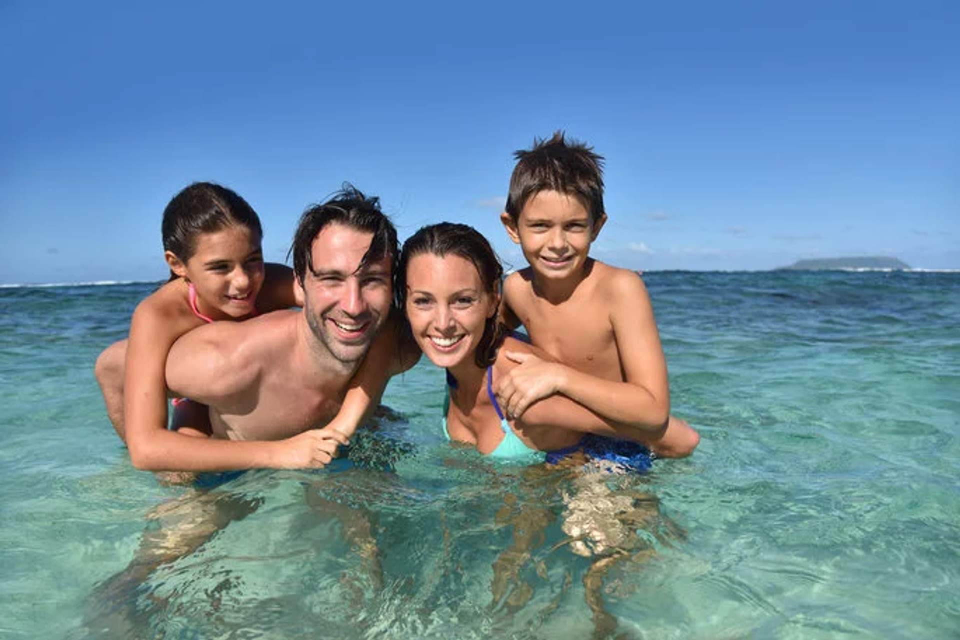 Family enjoying a day in the clear ocean waters, perfect for kid-friendly activities in Cancun.