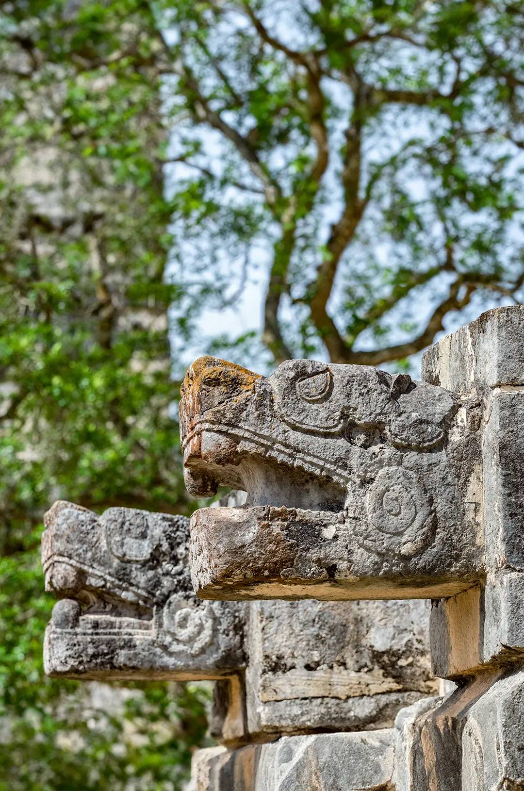 Cabezas de serpiente emplumada talladas en piedra en Chichén Itzá, símbolo de la cultura maya.