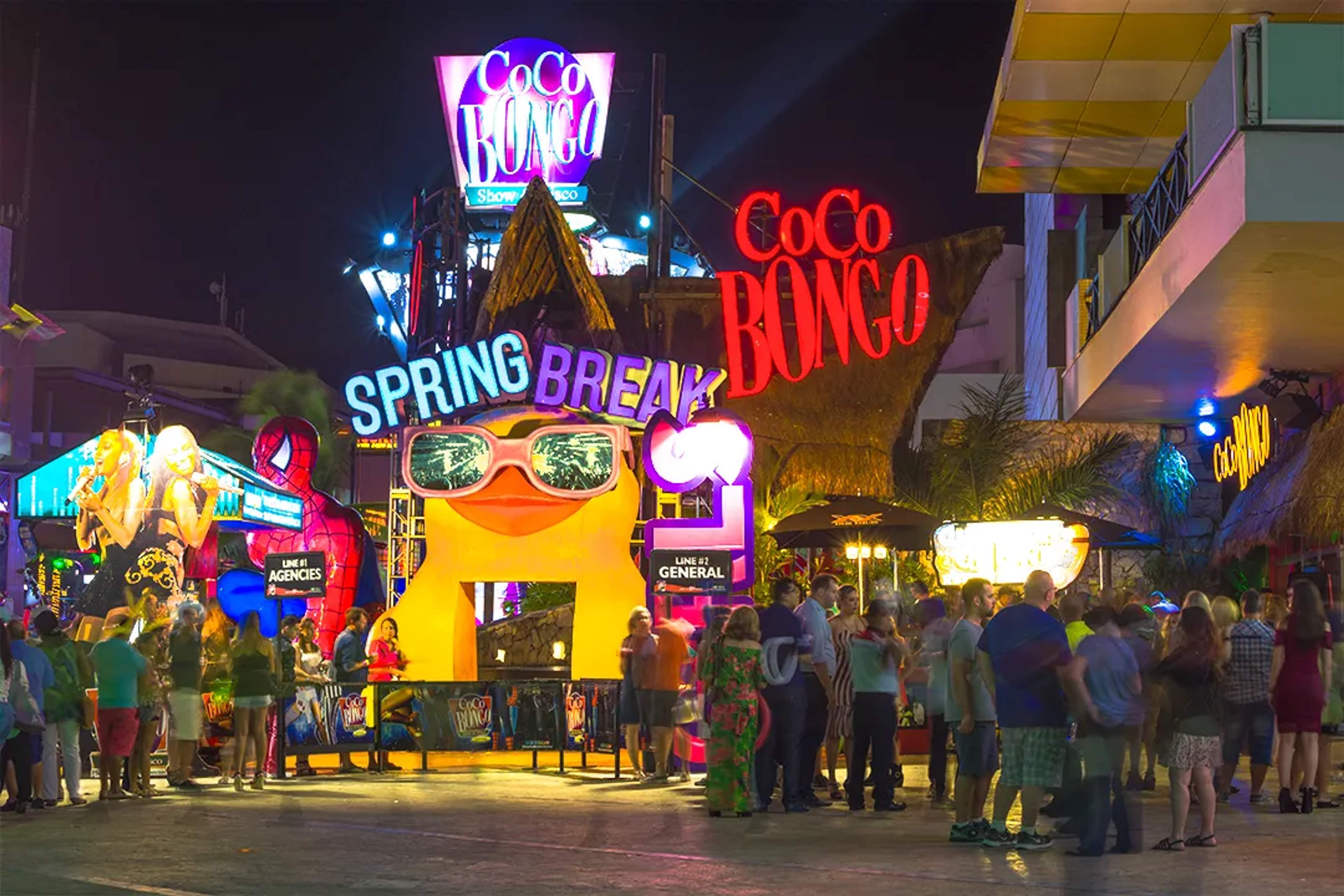 Entrada de Coco Bongo Cancún con luces neón, visitantes y ambiente vibrante en la Zona Hotelera