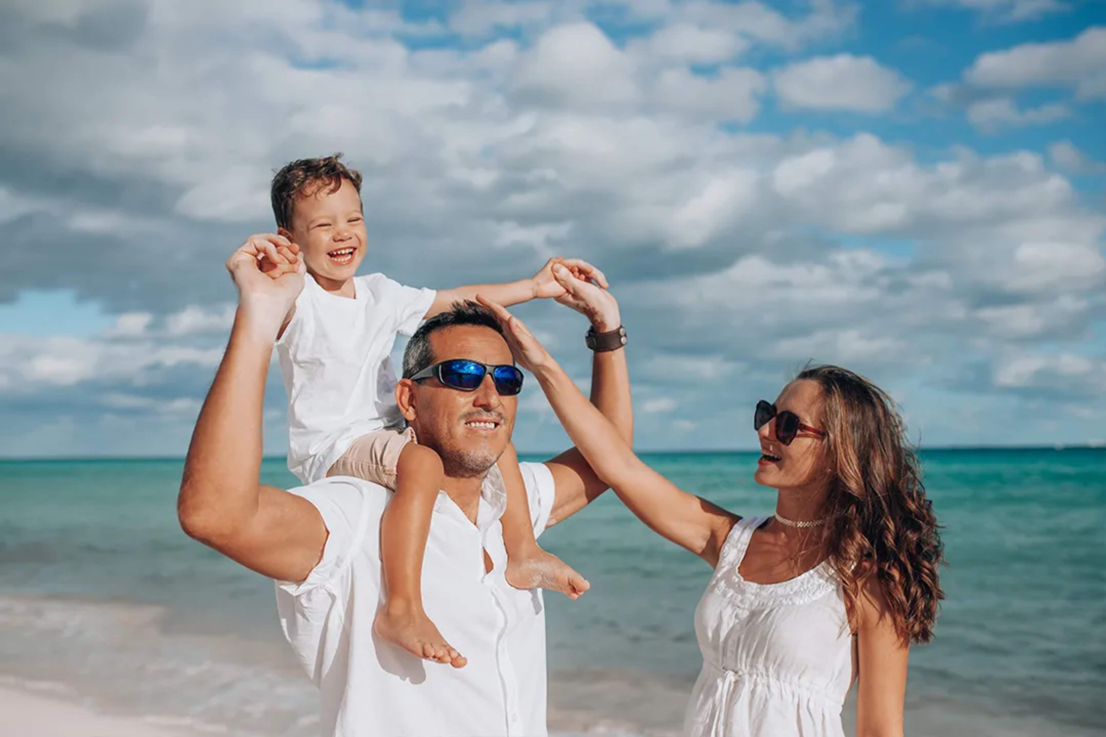 Happy family enjoying a beach day in Tulum, Mexico, with turquoise sea, white sand, and a relaxed tropical vibe