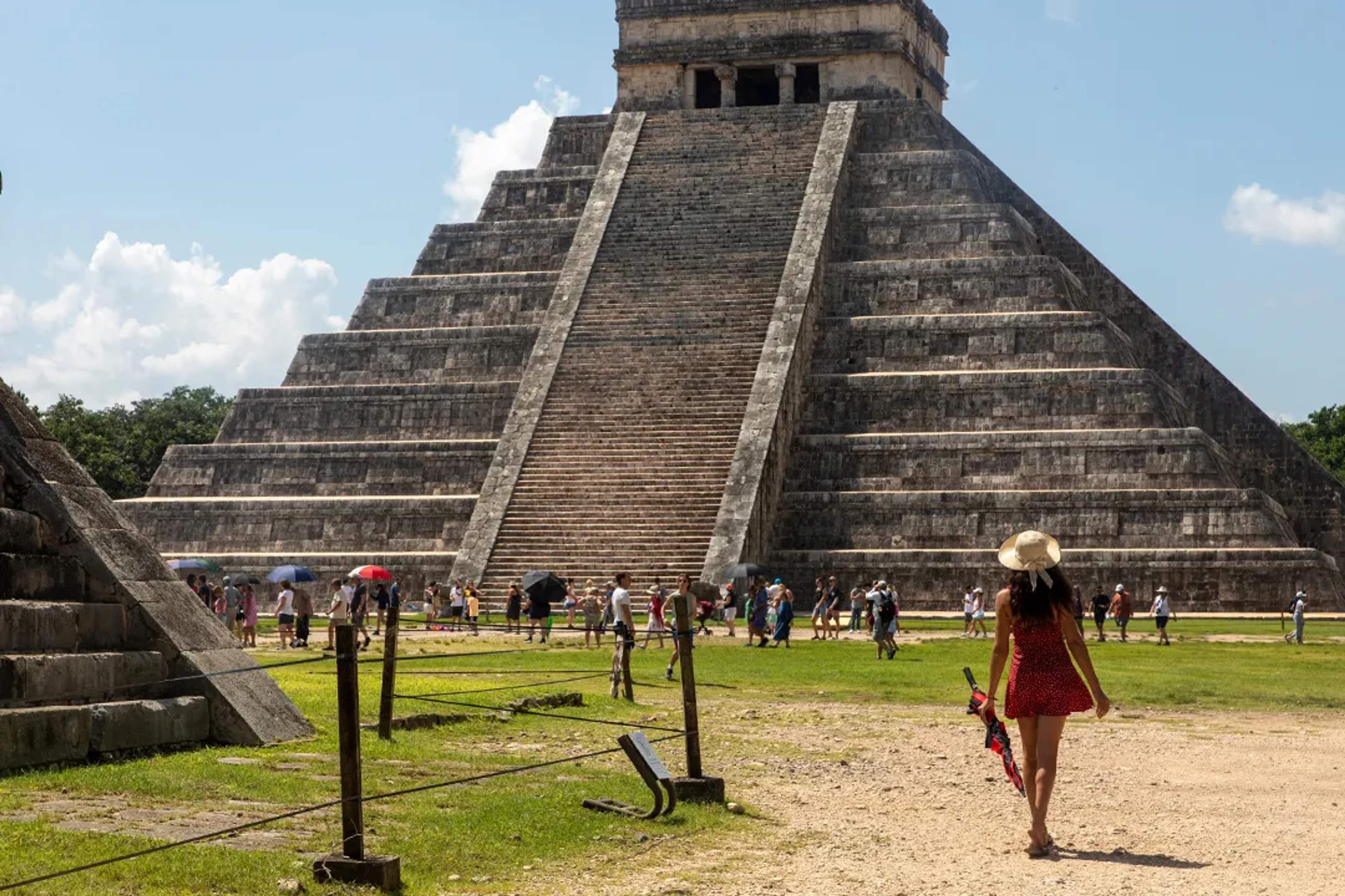Visitantes caminando hacia la pirámide El Castillo en Chichen Itza, ruinas mayas icónicas de Yucatan, Mexico