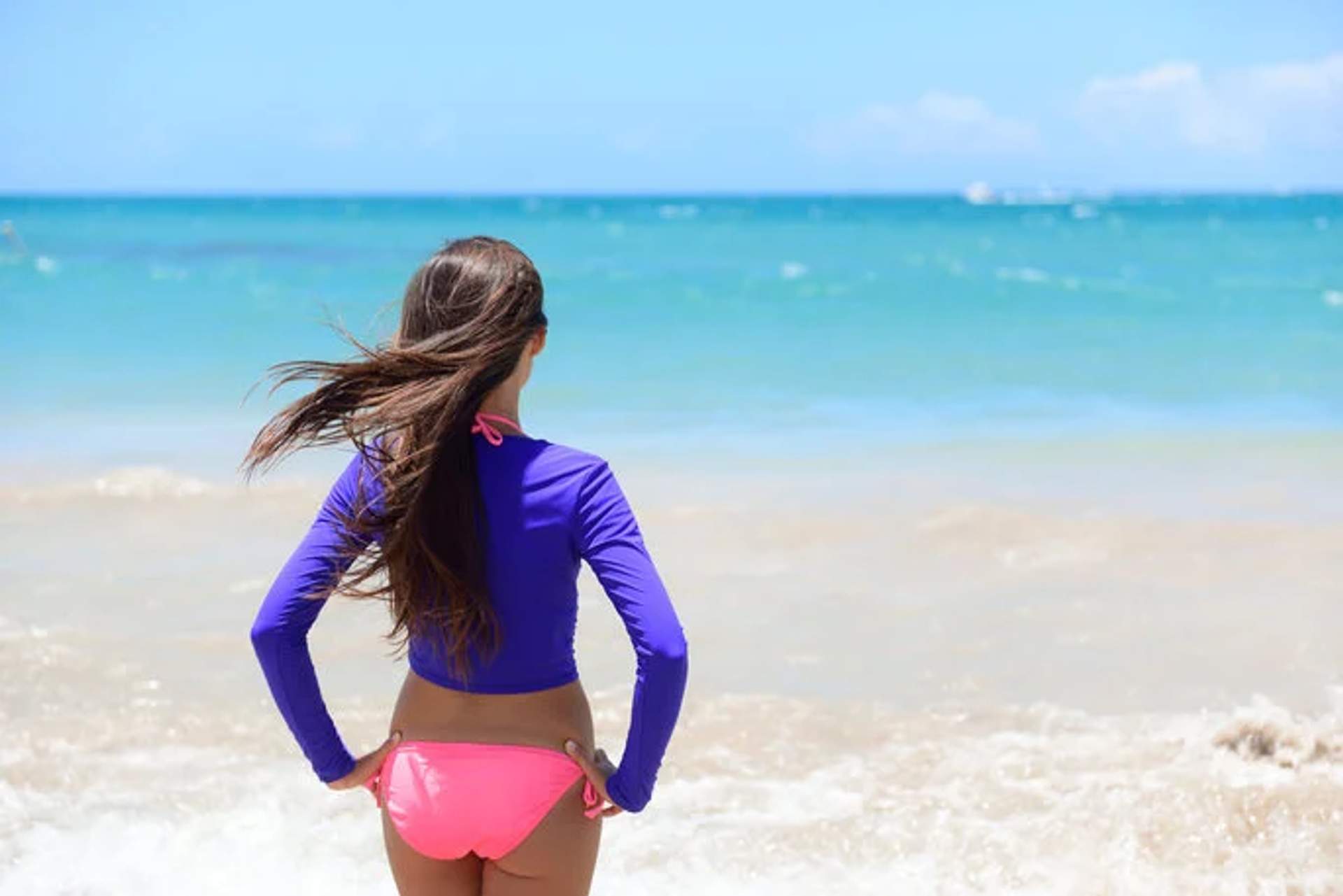 deal Cancun attire: a swimsuit with a long-sleeve top for sun protection at the beach.
