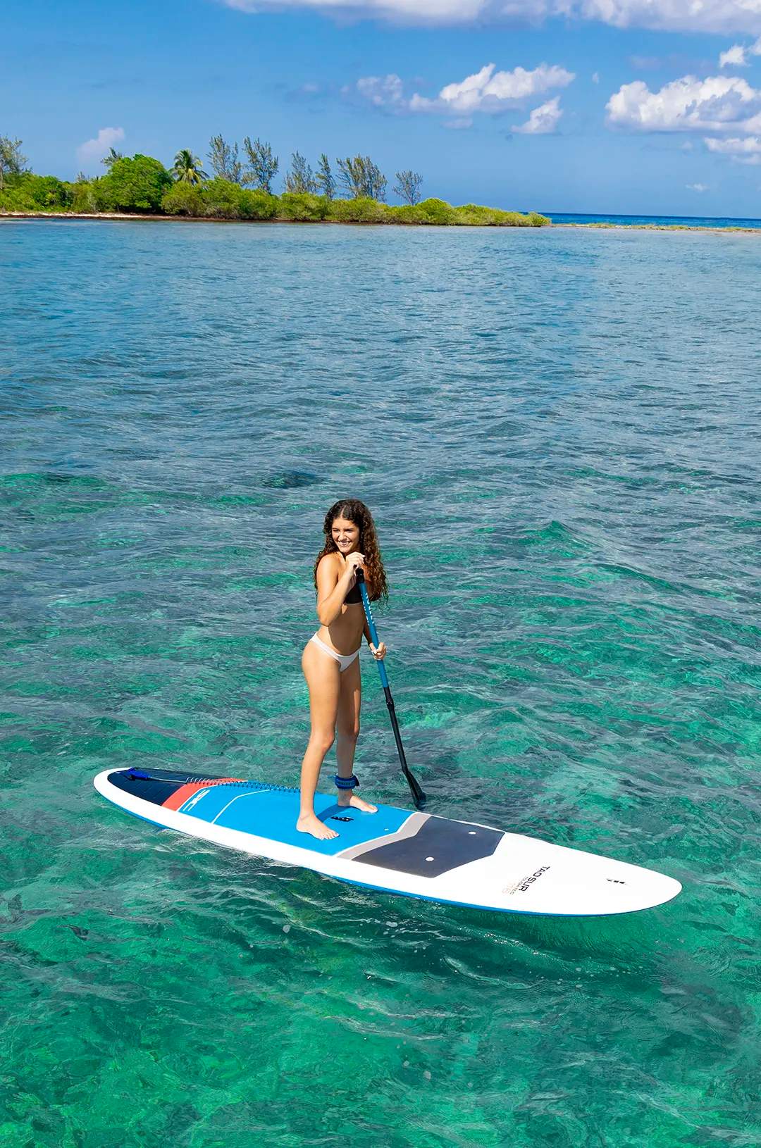 Young lady paddle boarding in Puerto Morelos bay