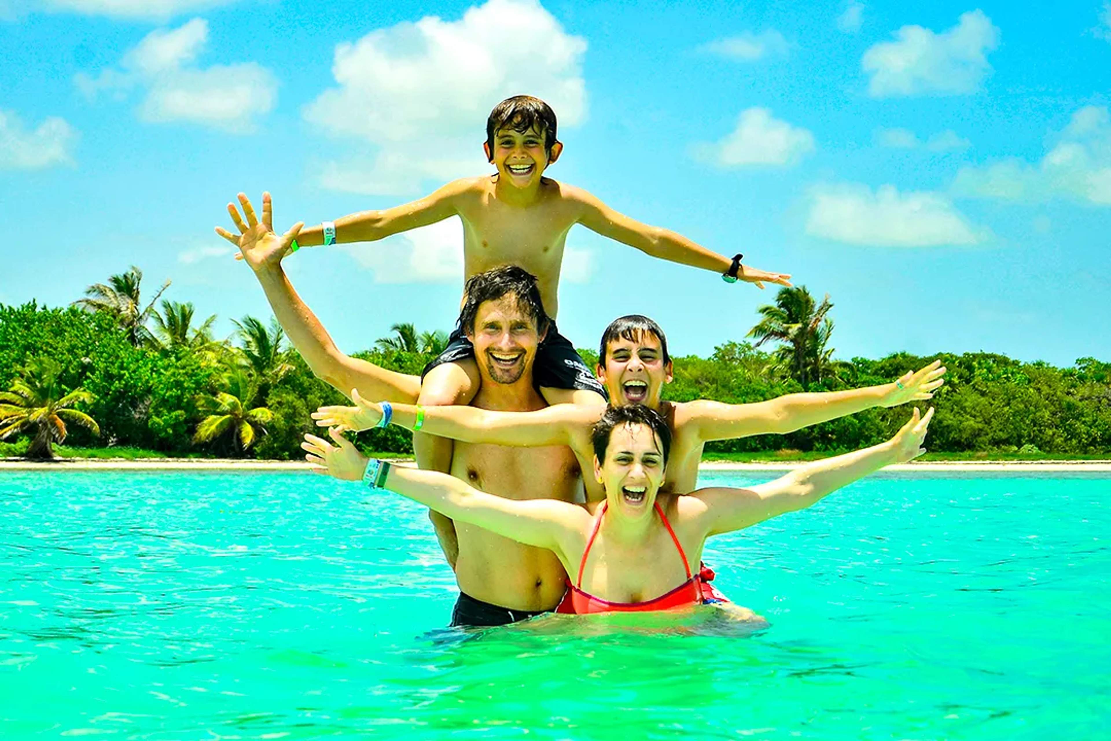 Family having fun in turquoise Caribbean waters, enjoying a tropical beach day in Cancun, Mexico