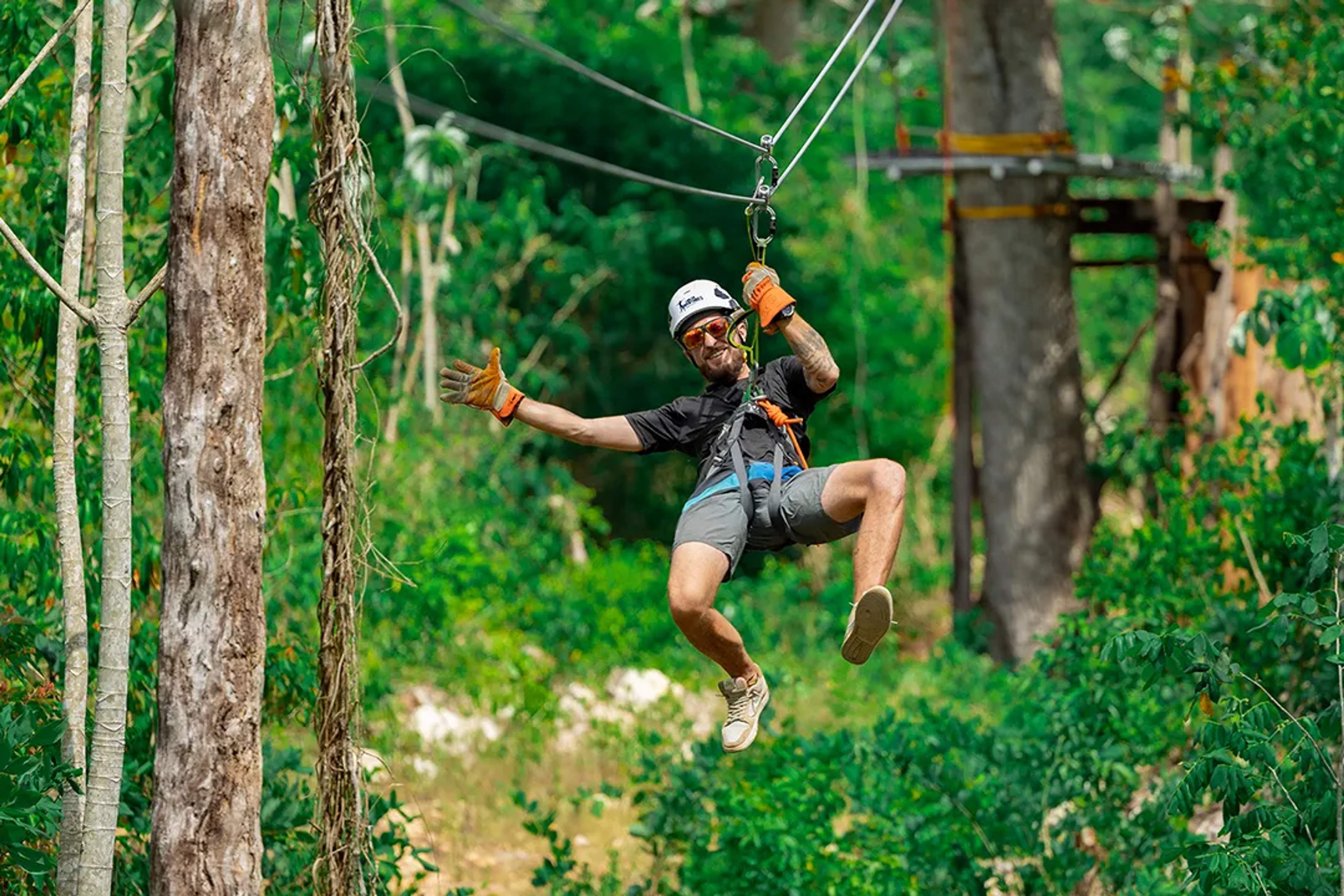 Zipline adventure through lush jungle canopy with traveler gliding between trees on an adrenaline-filled tour
