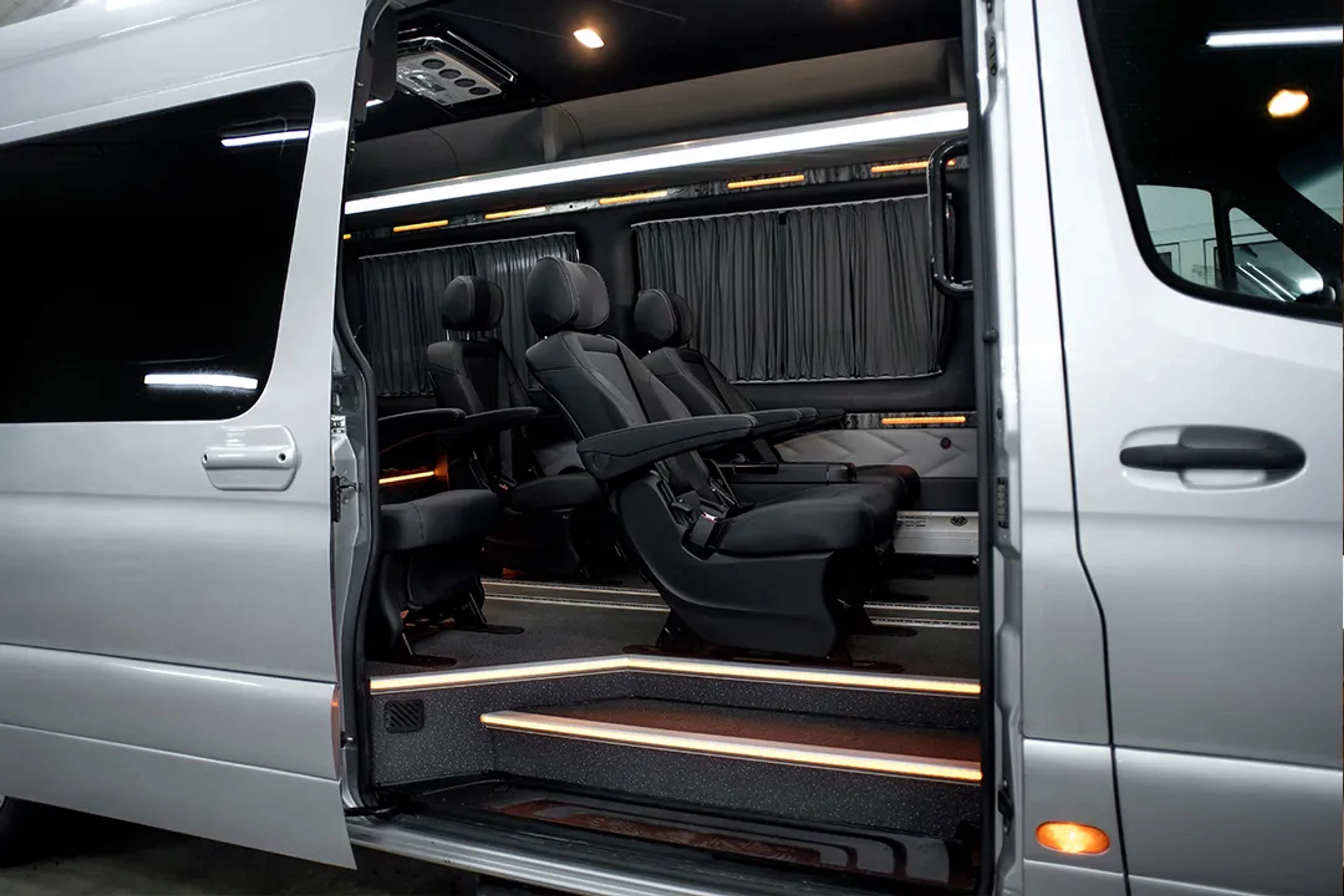 Luxury van interior with leather seats and ambient lighting, ready for a premium ride.