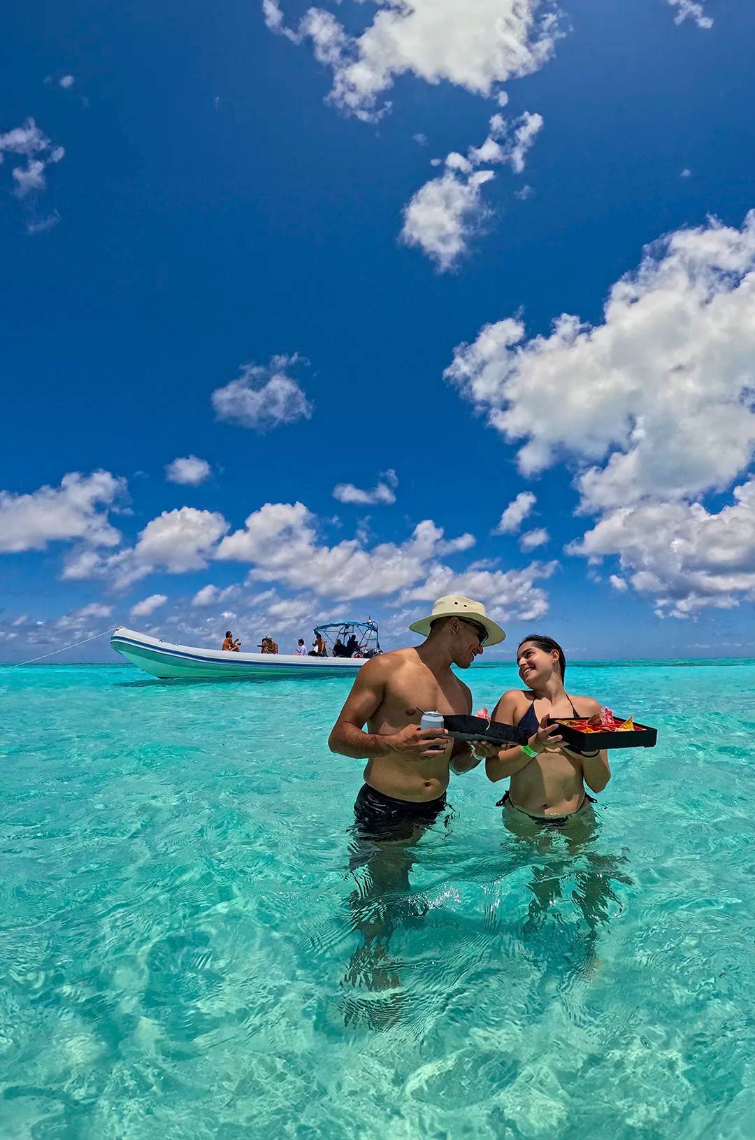 Snorkel en El Cielo, Cozumel: Pareja disfrutando de un almuerzo en aguas cristalinas cerca del bote.