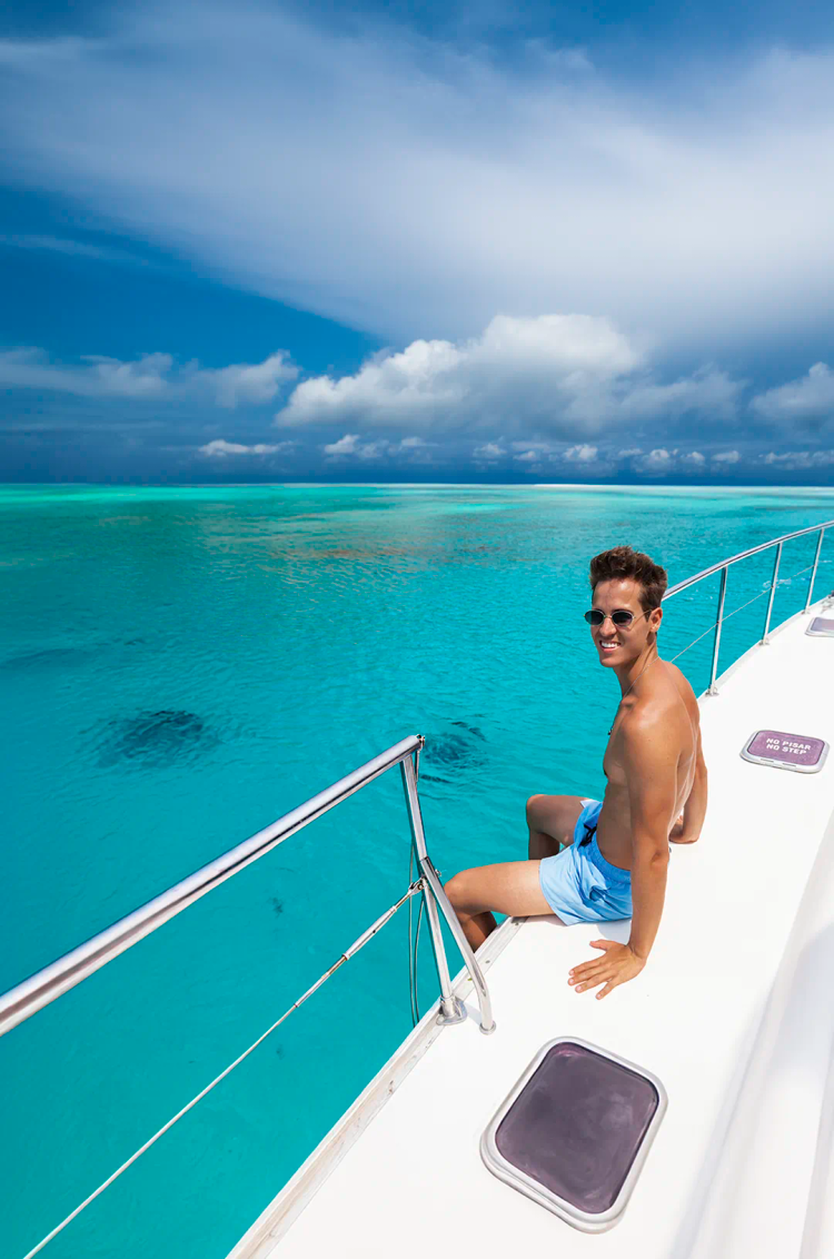 Young man enjoying the view of the Mexican Caribbean from a Cozumel catamaran.