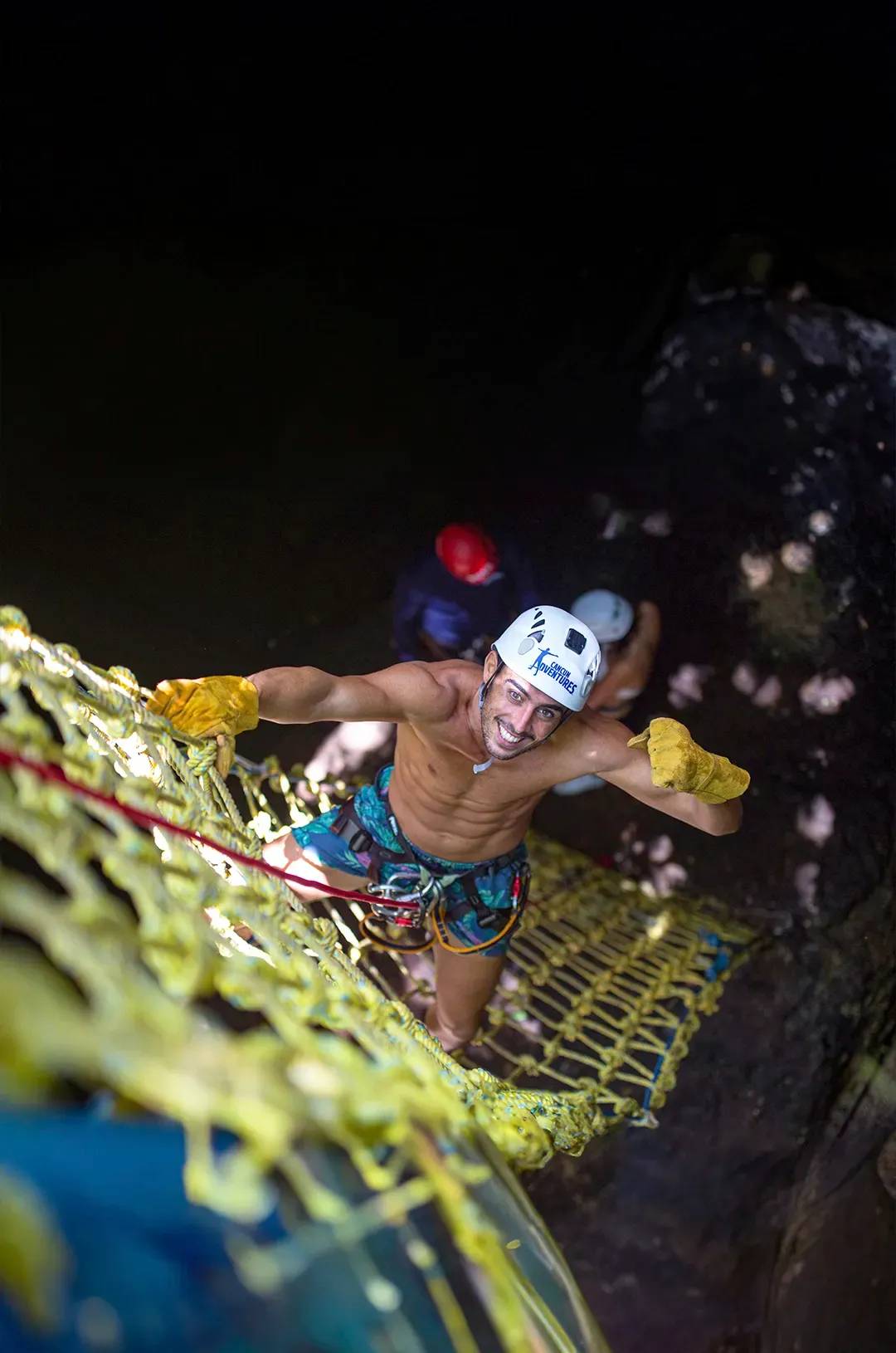 Man climbing a rope net in an outdoor adventure in Cancun