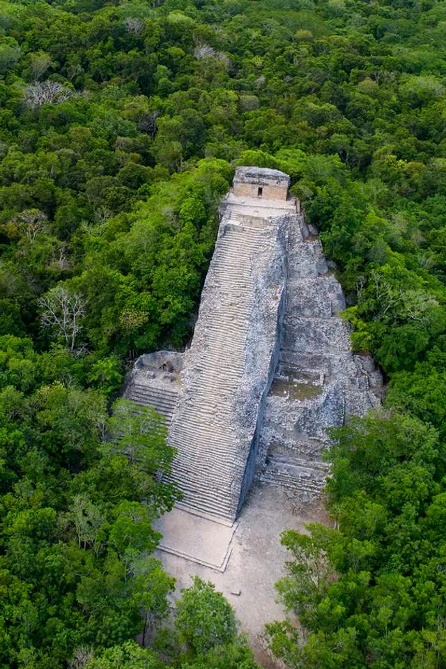 Coba ruins, aerial view of a Mayan pyramid surrounded by dense vegetation.