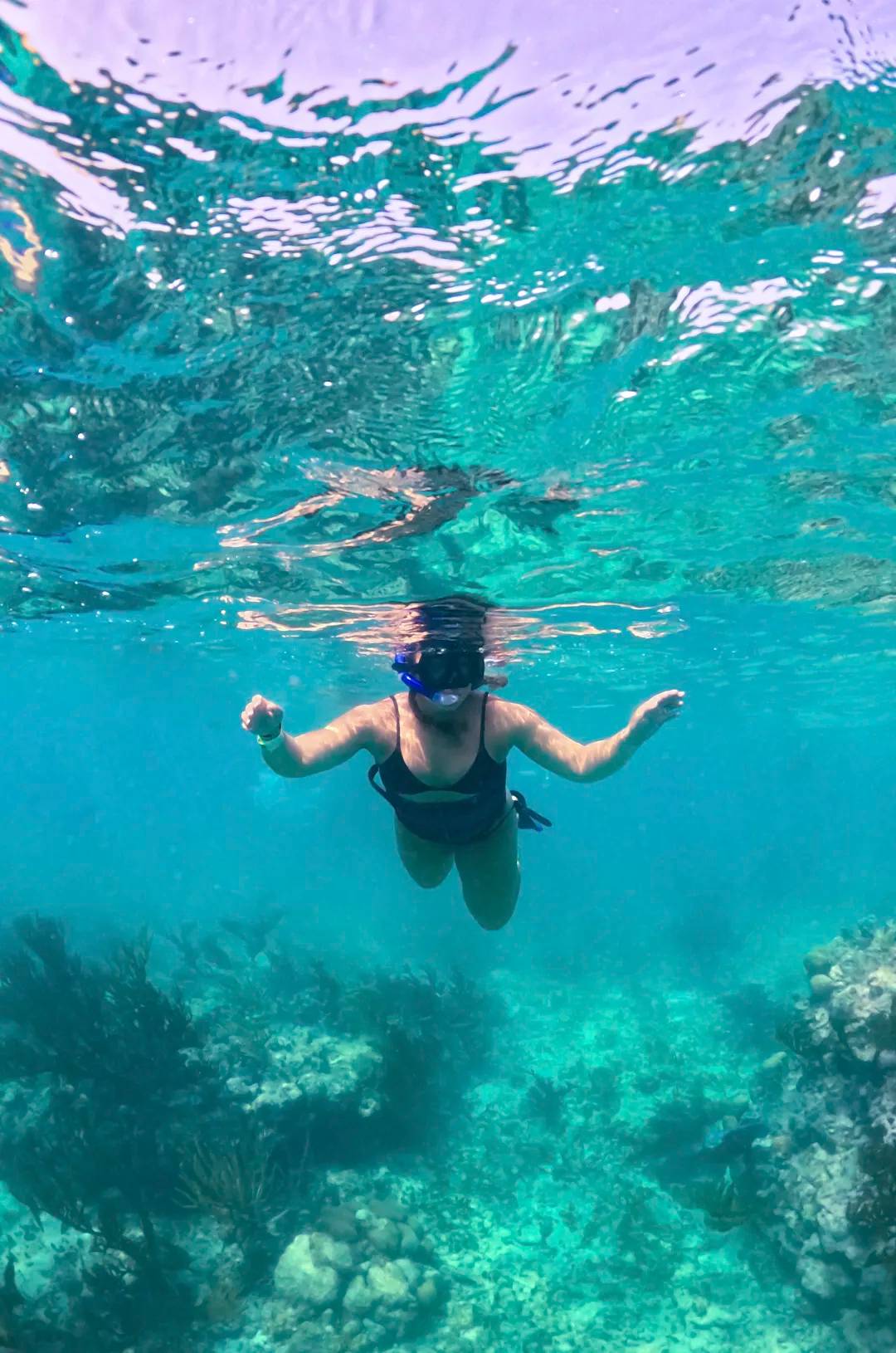 Lady snorkeling in clear Puerto Morelos bay waters
