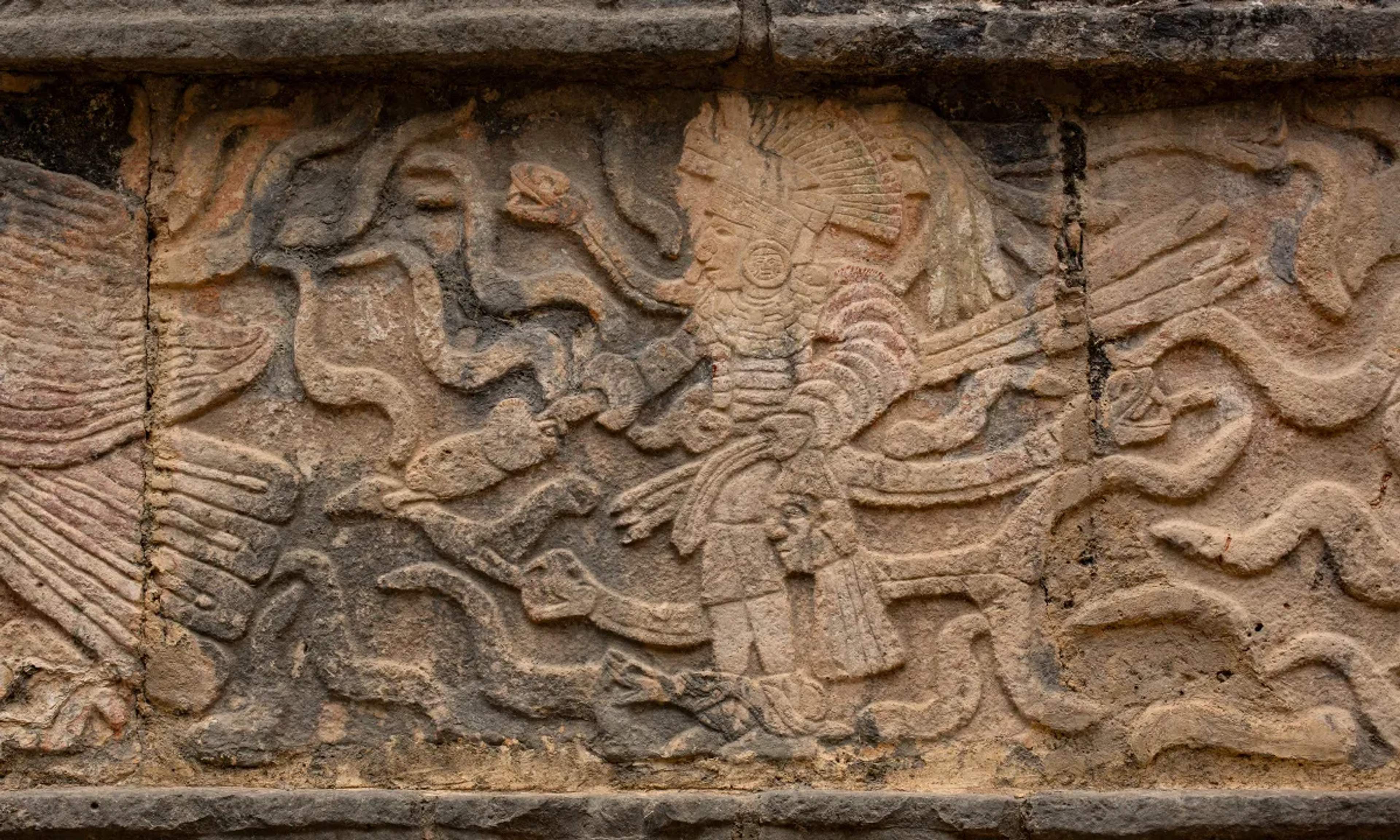 Relieve de piedra en Chichén Itzá que representa una figura maya con intrincados detalles simbólicos.