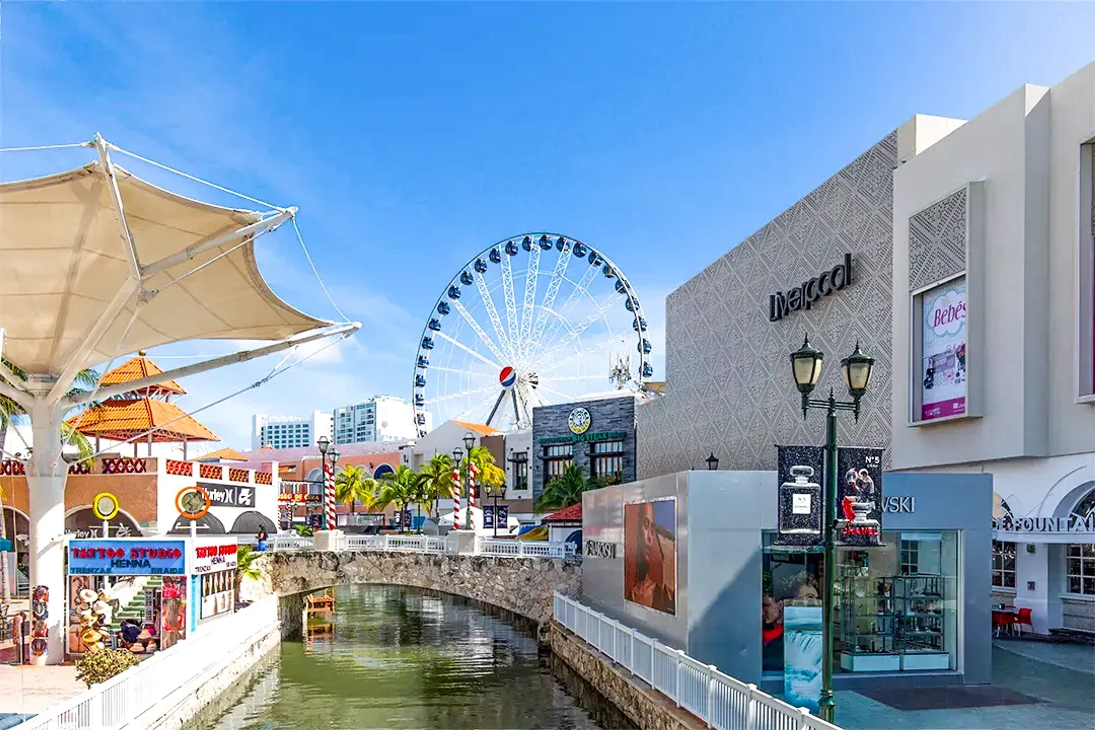 La Isla Shopping Village in Cancun with Ferris wheel, canal views, shops, and sunny outdoor shopping atmosphere