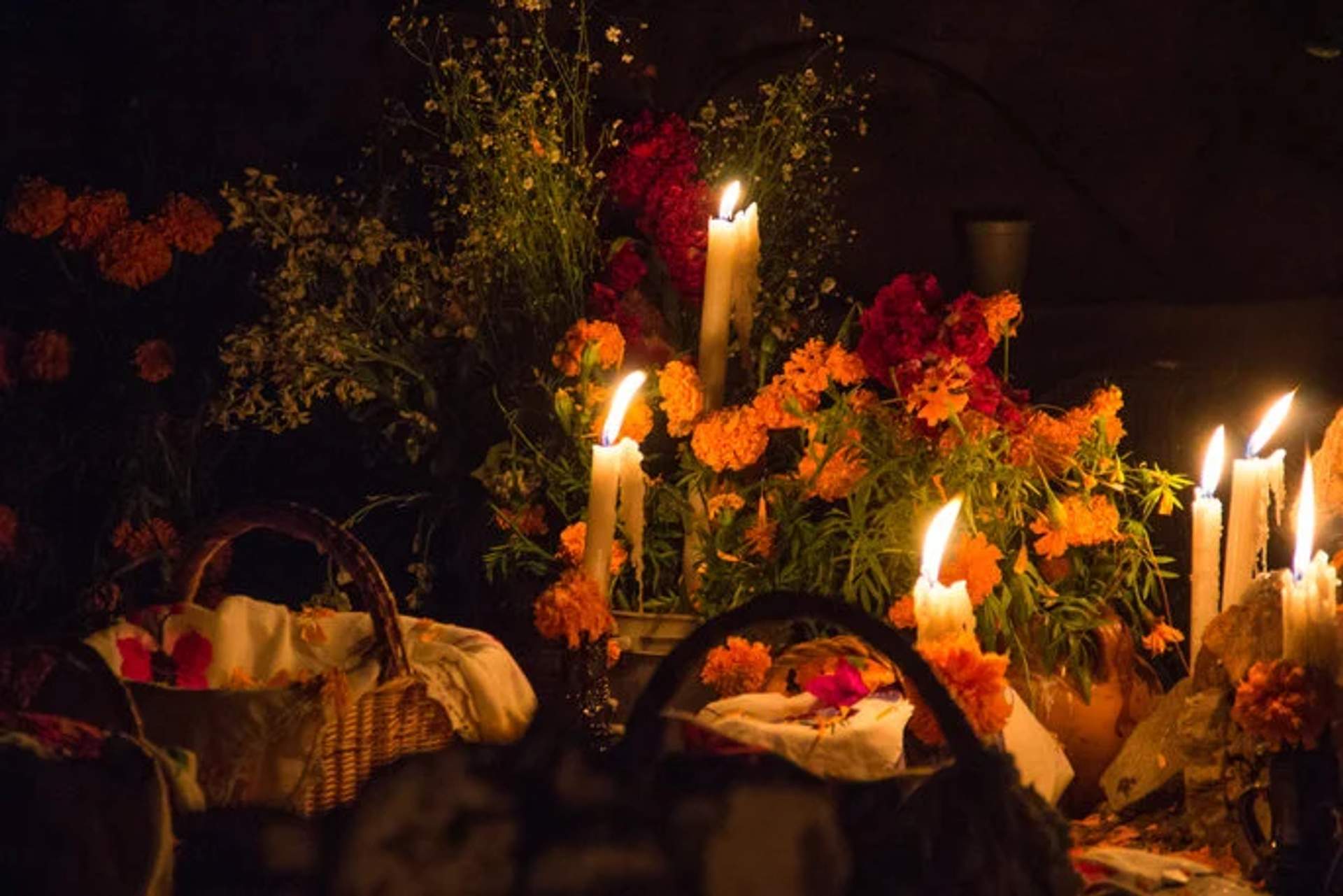 Altar con velas y flores de cempasúchil durante la celebración del Día de Muertos.