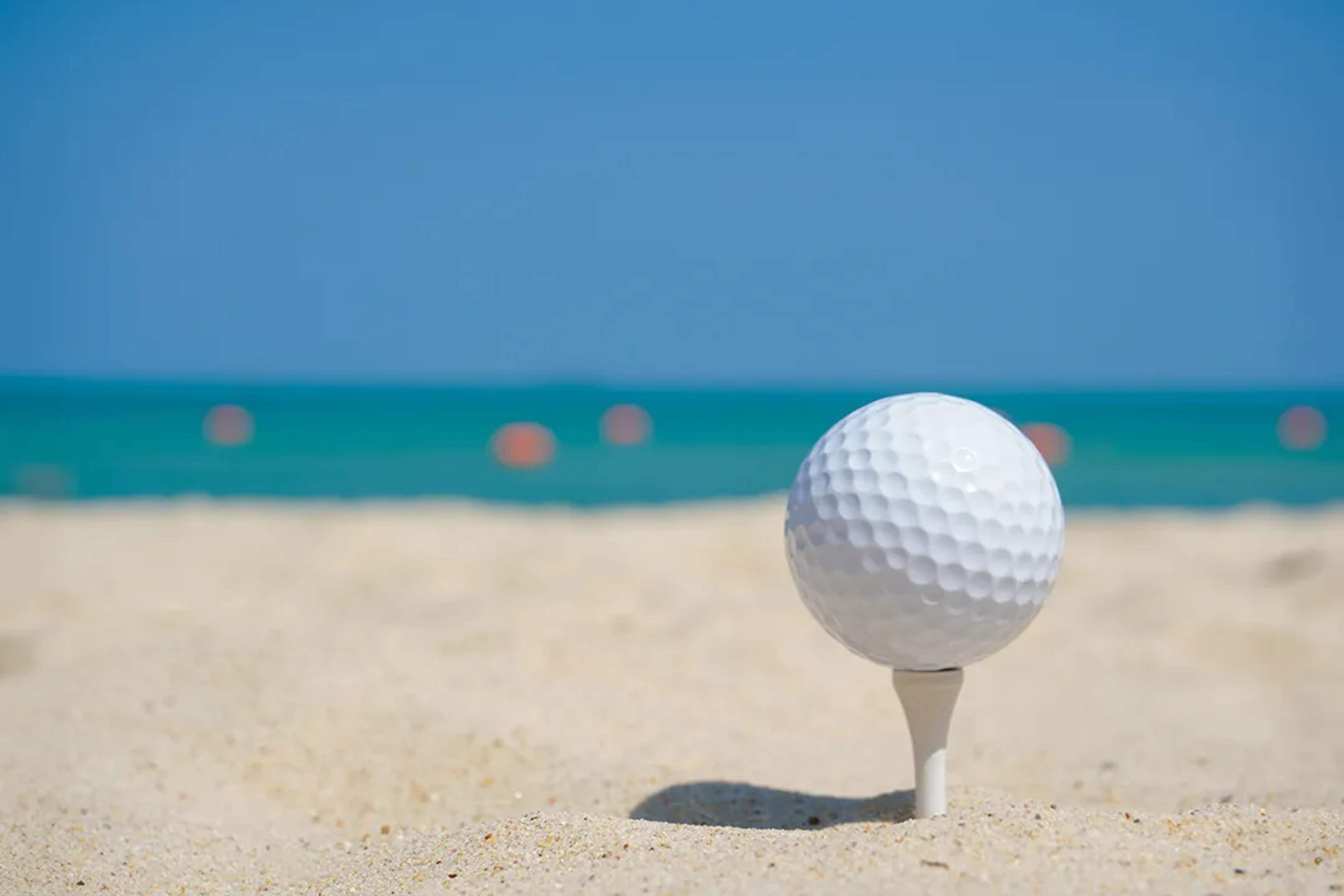 Golf ball on sand, representing Cancun's golf courses.