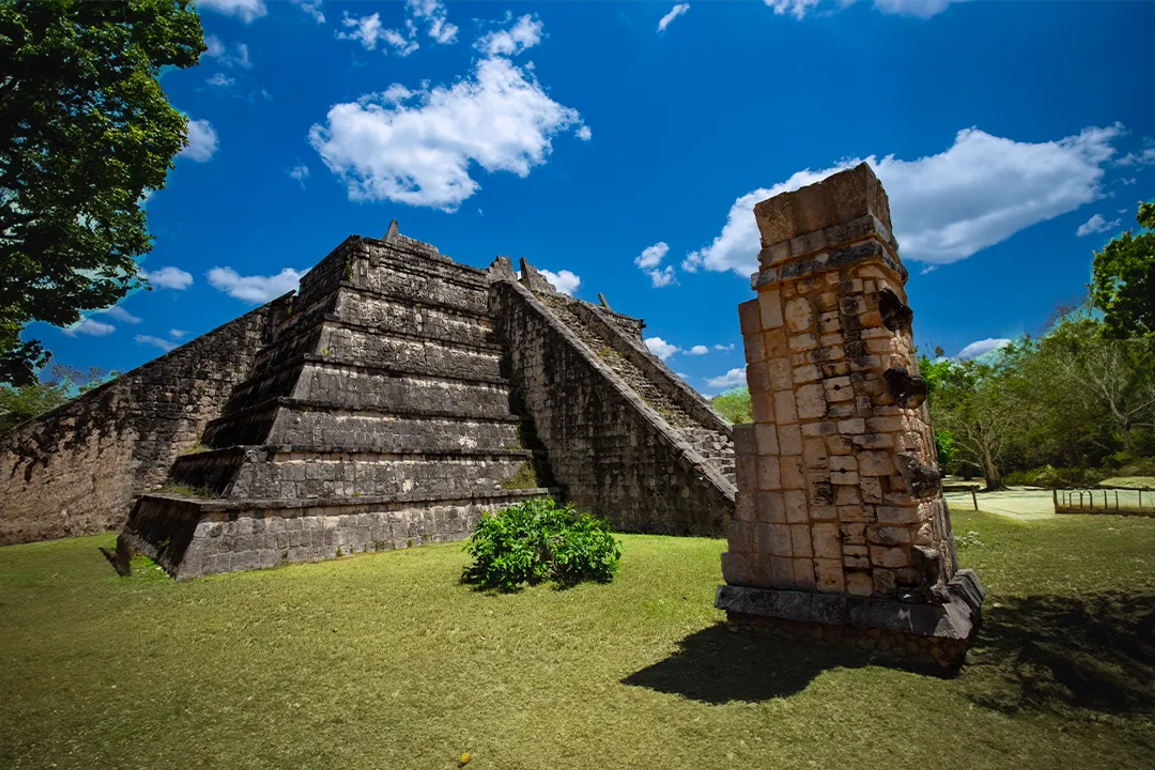 La pirámide de El Osario en Chichen Itzá bajo un cielo azul, mostrando la antigua arquitectura maya.