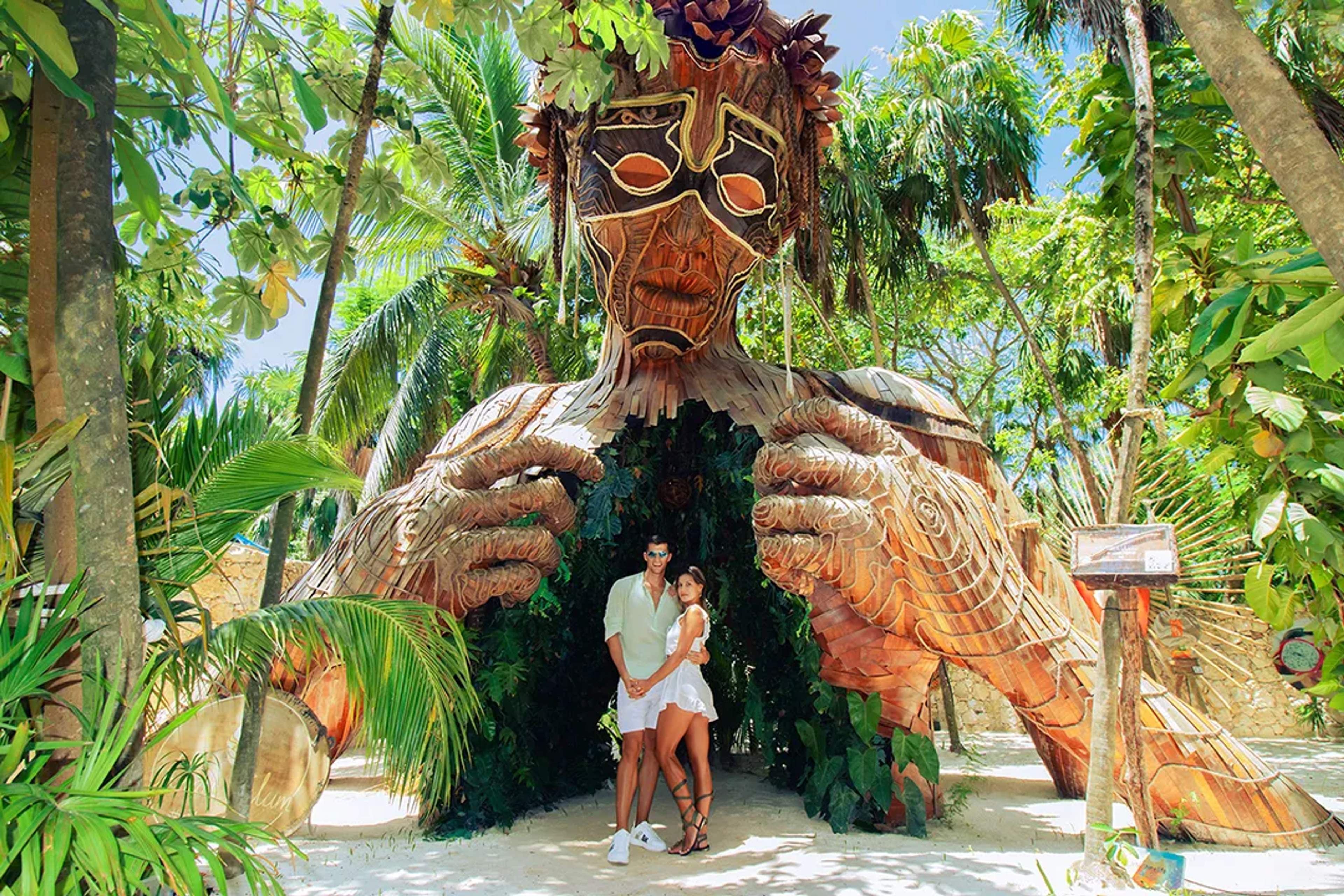 Couple posing at the Xibalba cenotes experience entrance, surrounded by jungle and Mayan underworld-inspired art
