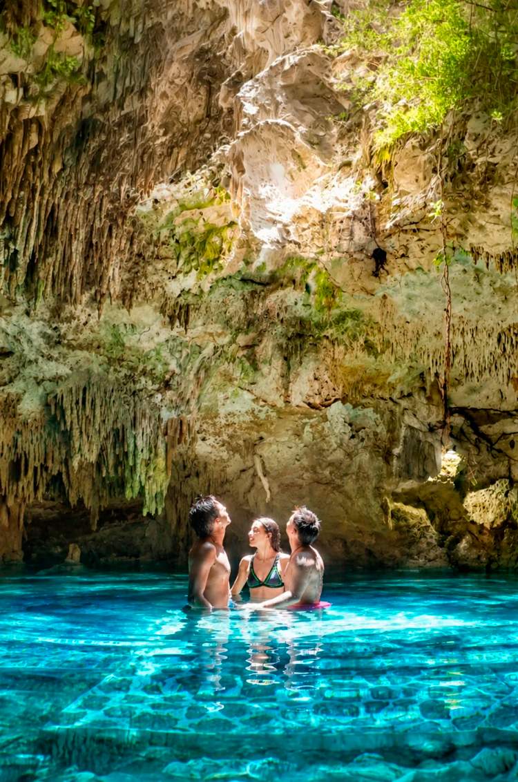Grupo de amigos nadando en un cenote cerca de Akumal.