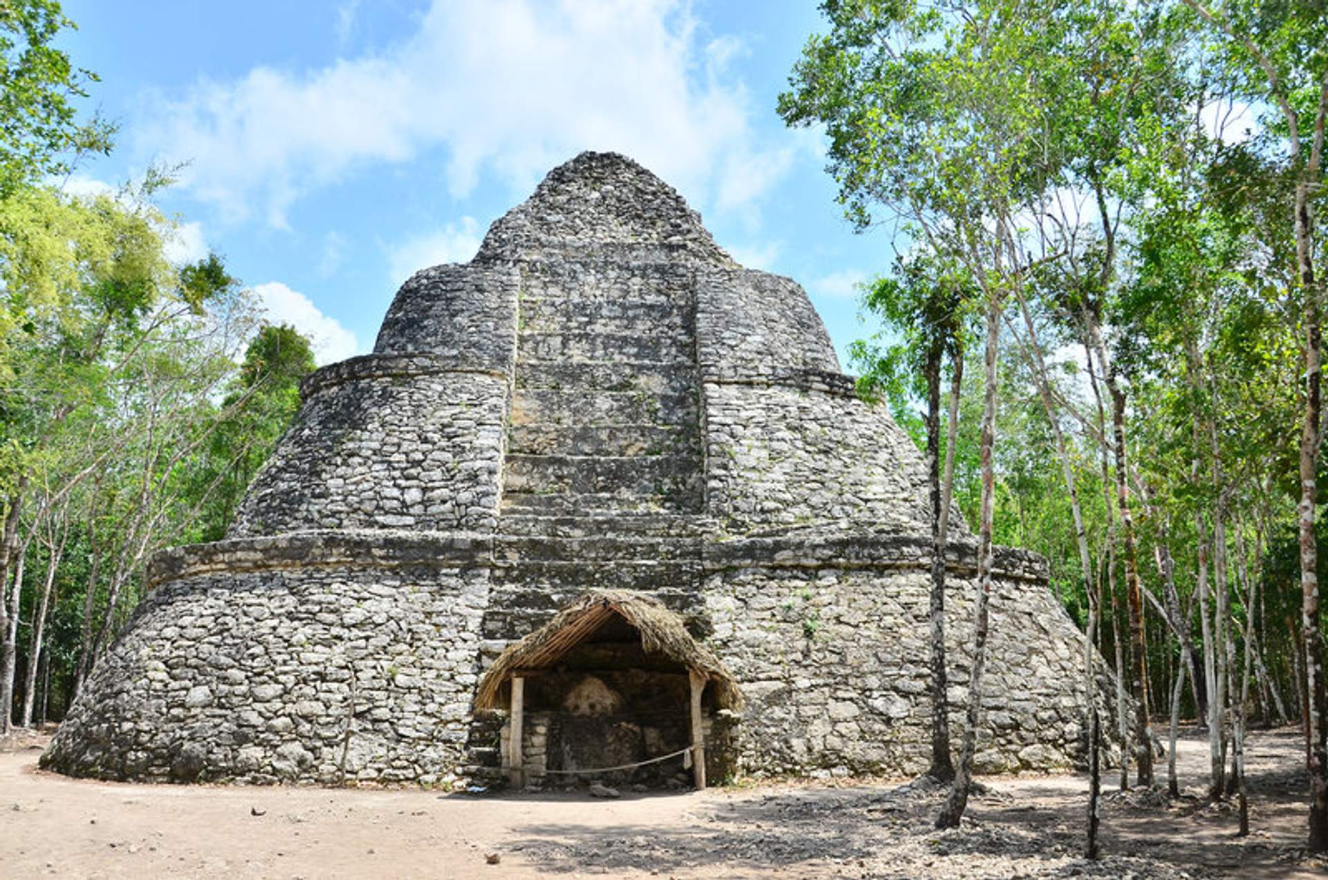 Templo circular de Cobá rodeado de selva, destacando su diseño de piedra y estructura antigua.