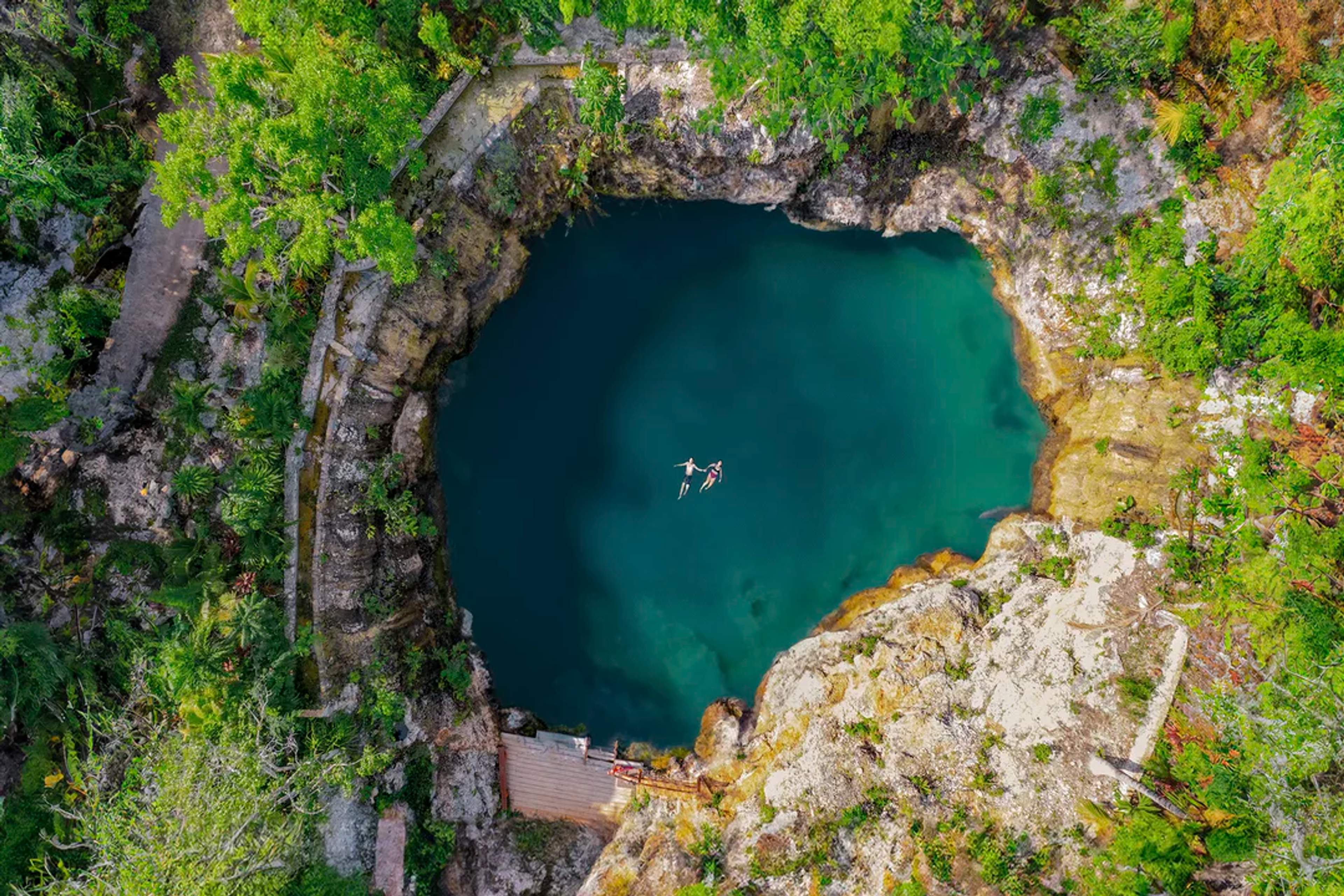 Float in crystal-clear waters surrounded by jungle at the stunning Cenote Tulix in Tulum, Mexico.