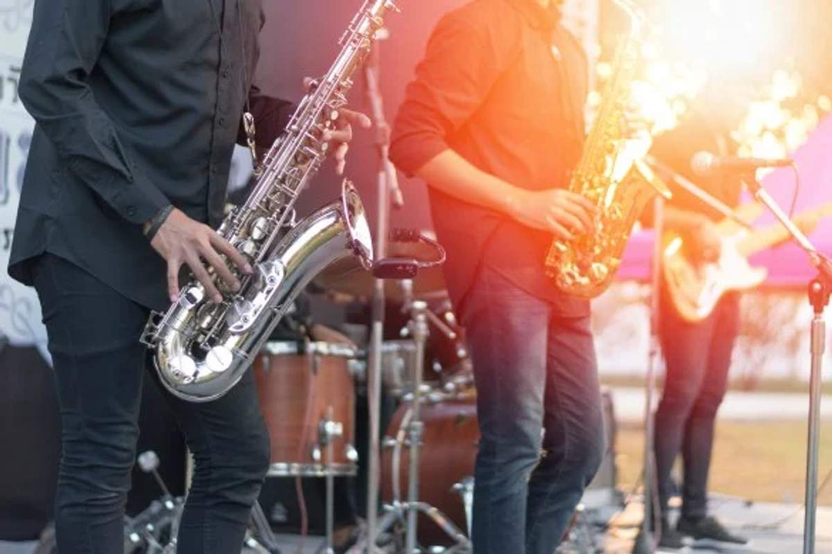 Músicos de jazz actuando en un festival en Cancún, con el atardecer de fondo