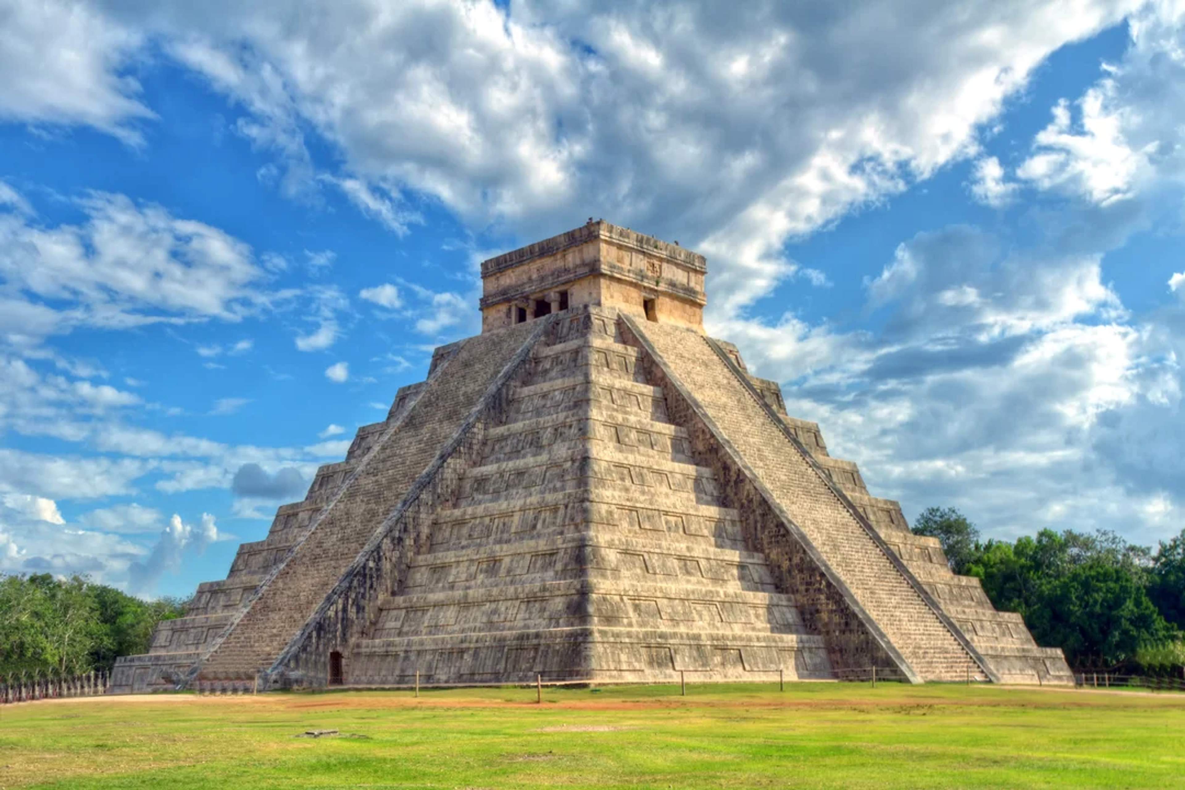 El Castillo pyramid at Chichén Itzá rises majestically under a partly cloudy sky in Yucatán.