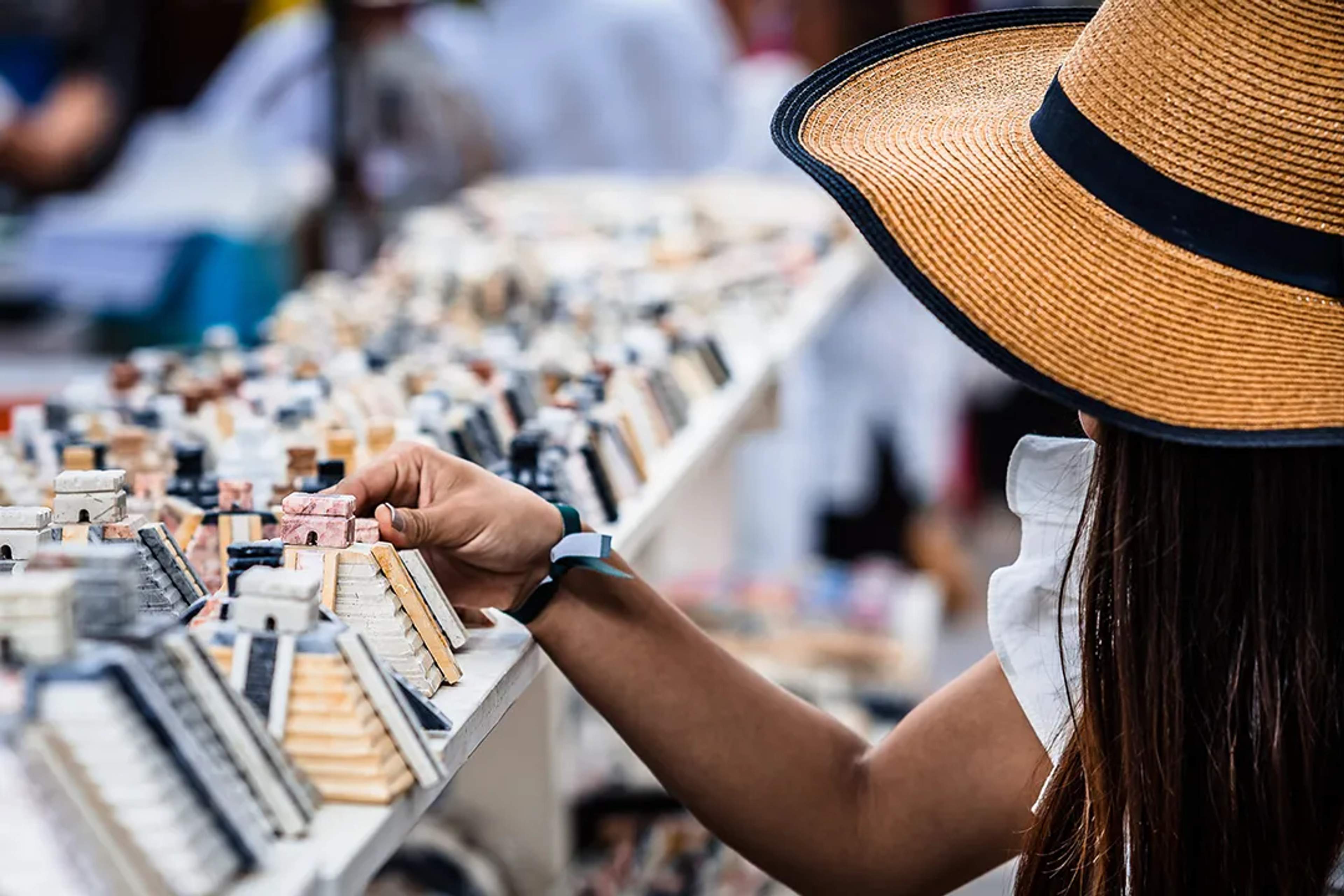 Traveler browsing handmade souvenirs and crafts at a local market in Cancun Mercado 28, showcasing authentic Mexican culture
