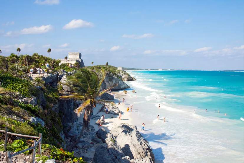 Tour en Tulum con ruinas frente al Caribe, templo en acantilado, arena blanca y mar turquesa abajo