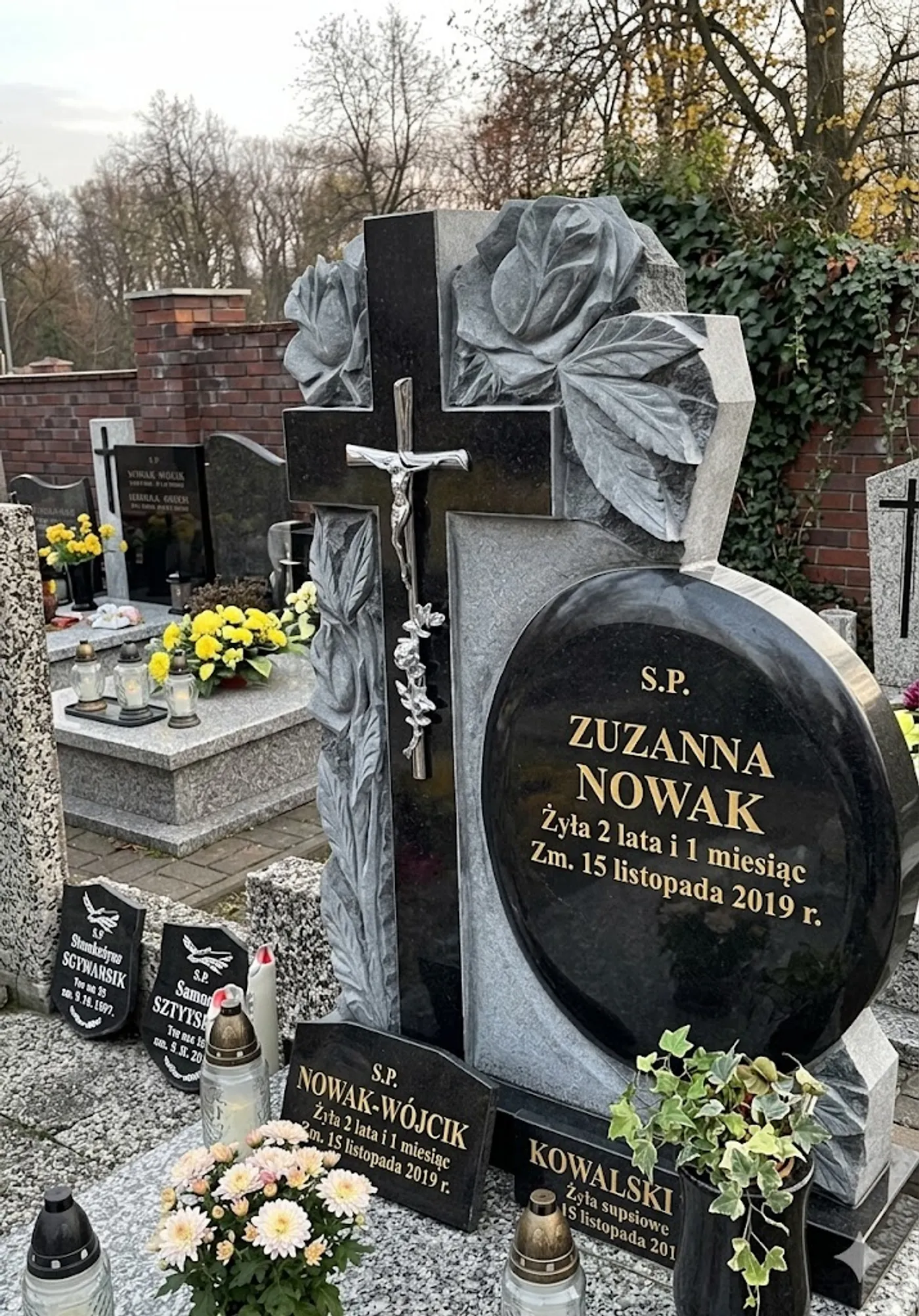 Zamontowana figura anioła z brązu na nagrobku z ciemnego granitu
