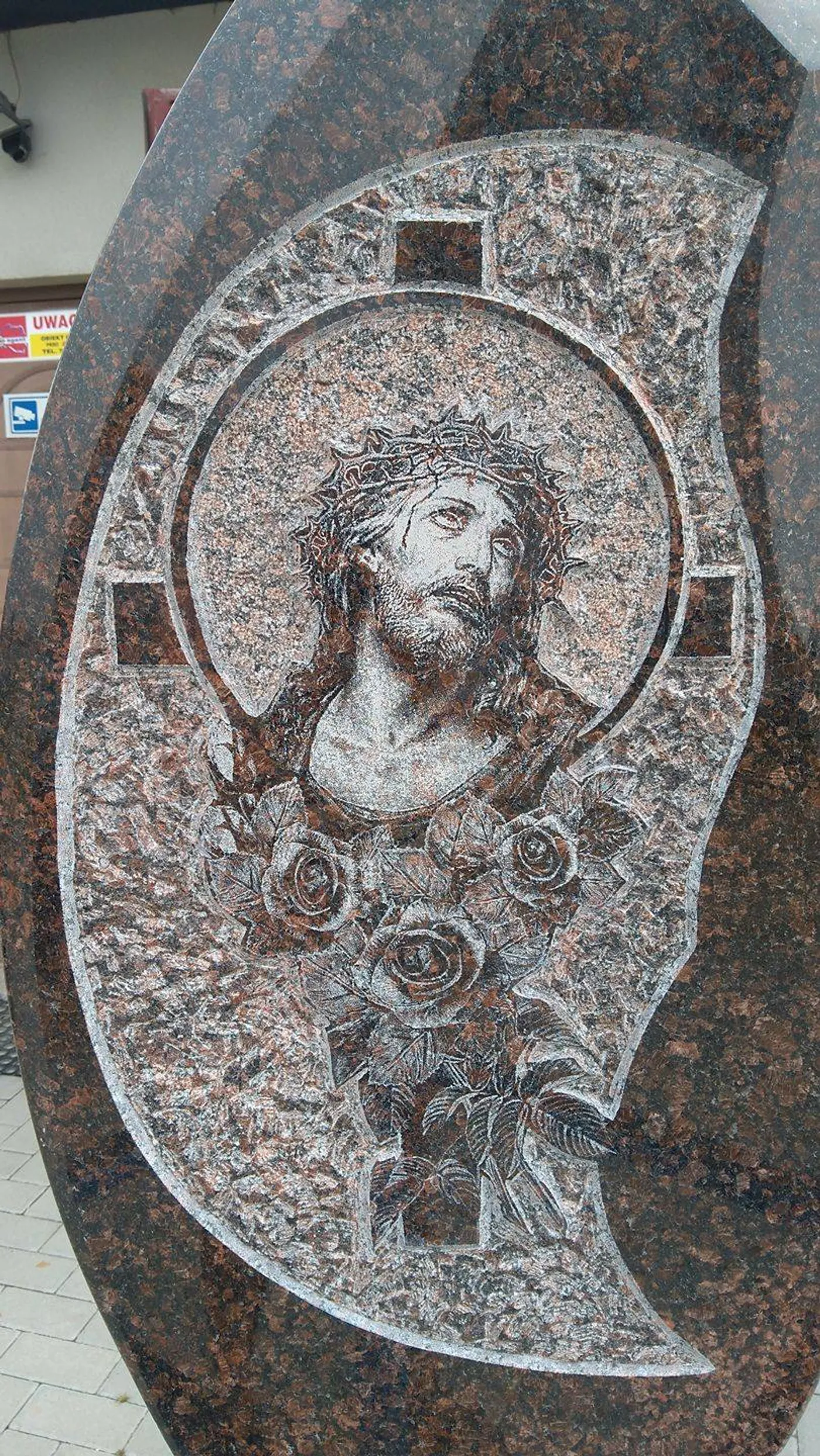 Piaskowany ornament roślinny i wizerunek Matki Boskiej na nagrobku z granitu