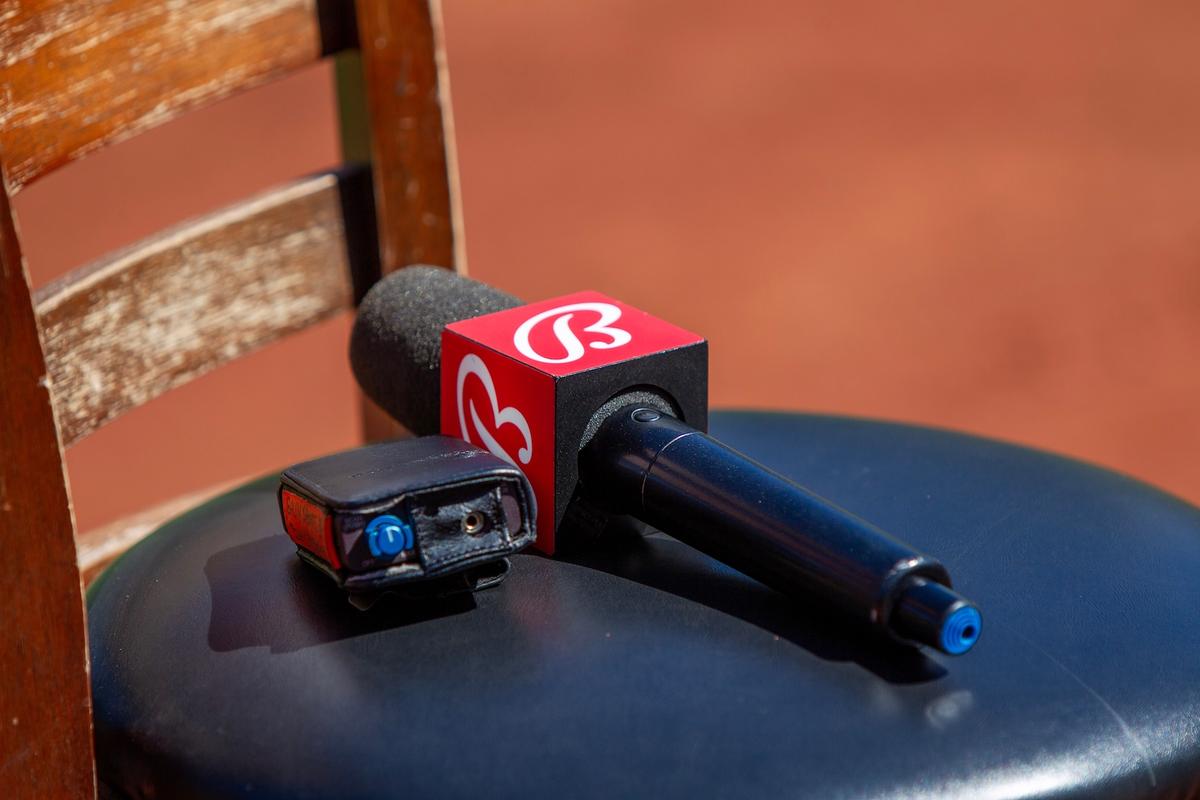 A Bally Sports microphone with a red logo flag rests on a black stool.