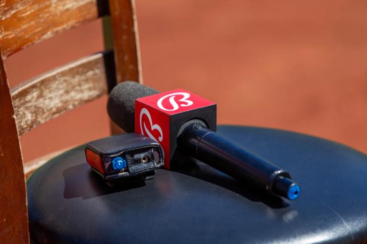 A Bally Sports microphone with a red logo flag rests on a black stool.