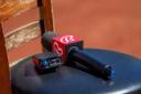 A Bally Sports microphone with a red logo flag rests on a black stool.