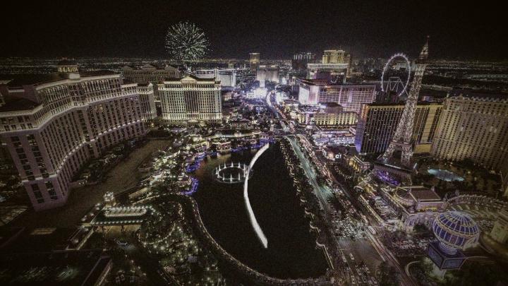 Nighttime aerial view of the Las Vegas Strip with illuminated resorts, the Bellagio fountains,