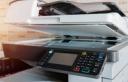 Close-up of an office copier and scanner machine with the lid slightly open.