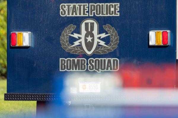 Rear of a blue State Police Bomb Squad vehicle featuring the unit's logo and text.