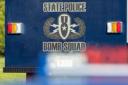 Rear of a blue State Police Bomb Squad vehicle featuring the unit's logo and text.