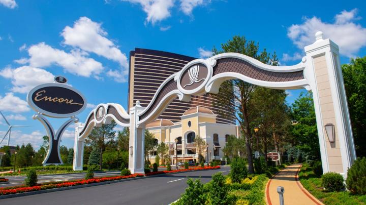 The entrance archway and sign of the Encore Boston Harbor resort with its bronze hotel tower in the background.