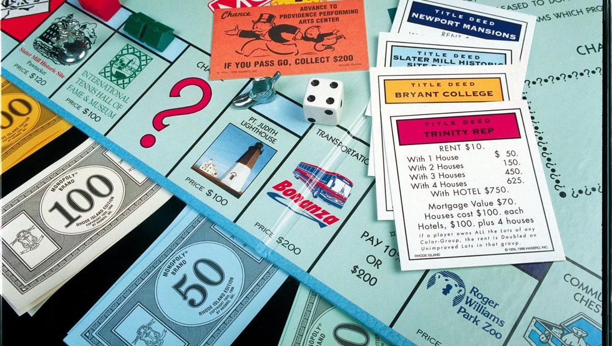 Close-up of a Rhode Island edition Monopoly board game with property cards, play money, a die,