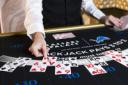 Close-up of a dealer's hands dealing cards on a Caesars Palace blackjack table.