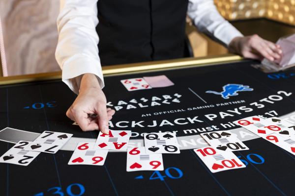 Close-up of a dealer's hands dealing cards on a Caesars Palace blackjack table.