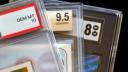 Close-up of three graded trading cards in plastic slabs, showing grades of GEM MT 10, 9.5 GEM MINT, and 8 NM MT.