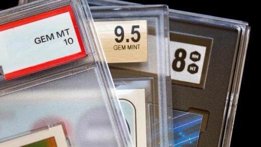 Close-up of three graded trading cards in plastic slabs, showing grades of GEM MT 10, 9.5 GEM MINT, and 8 NM MT.