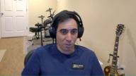 Michael Gagliano wearing headphones and a BetMGM Poker shirt, with a drum kit and electric guitar in the background.
