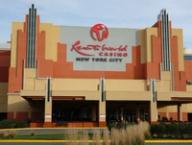 The exterior facade of Resorts World Casino in New York City, featuring its large red sign and modern architecture.